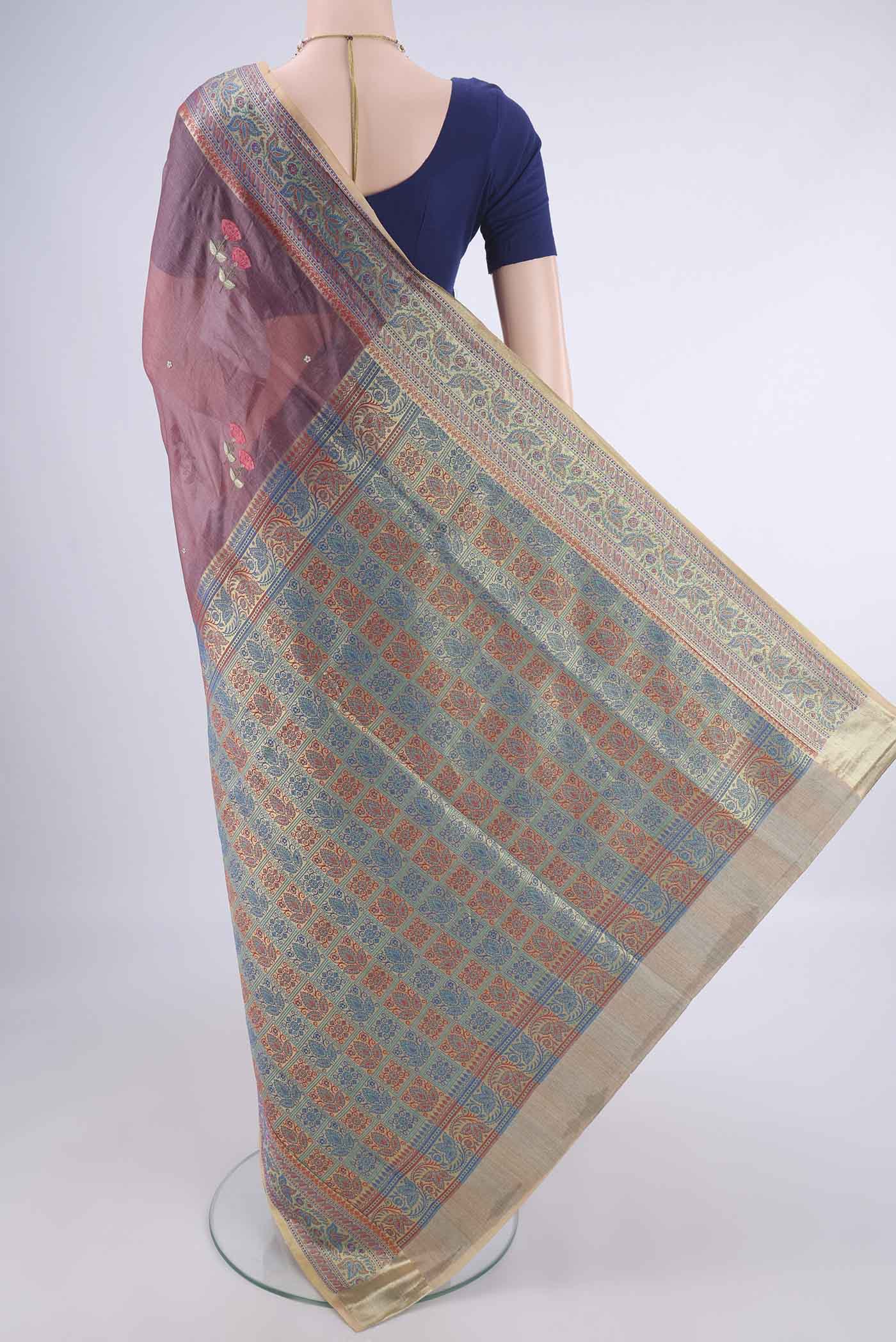 Flat view of Dark Mauve Banarasi Tussar Silk Saree with Embroidery on the body and Zari Border. 