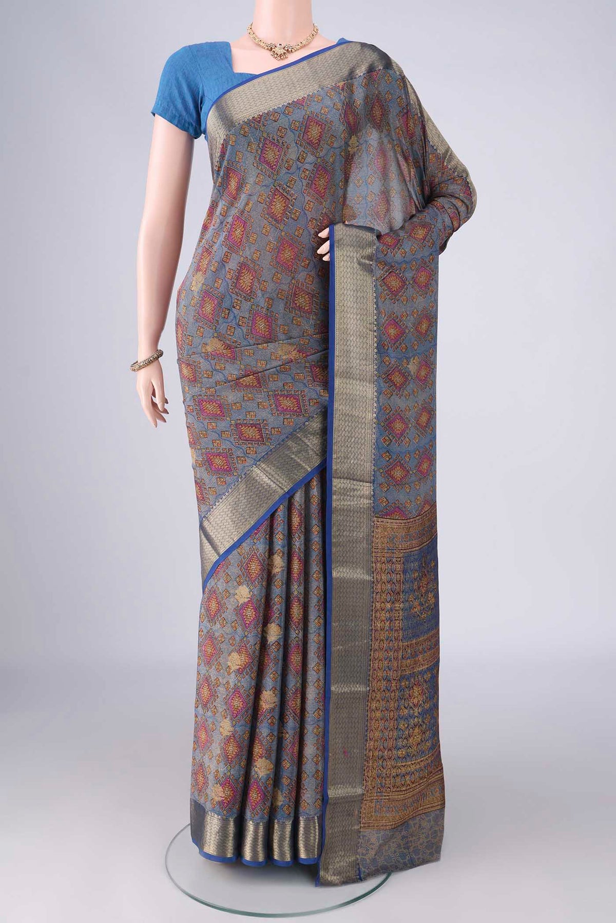 Light Blue Mysore Crepe Saree with Printed design on the body and Zari Border.  displayed on a mannequin