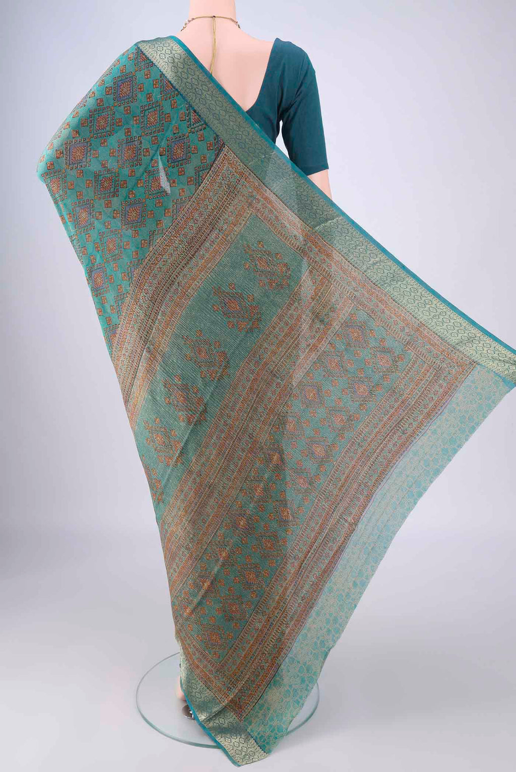 Flat view of Turquoise Crepe Saree with Floral Print on the body and Zari Border. 