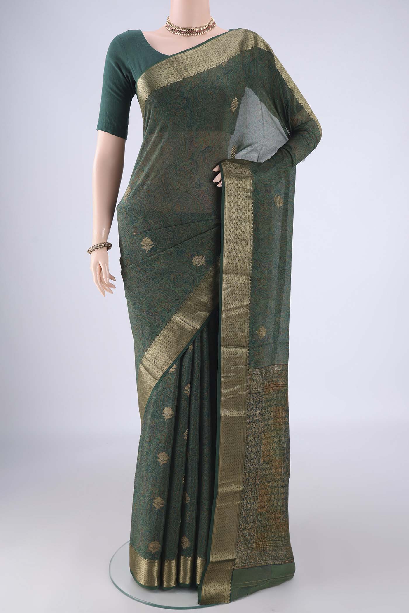 Bottle Green Crepe Saree with Floral Print on the body and Zari Border.  displayed on a mannequin