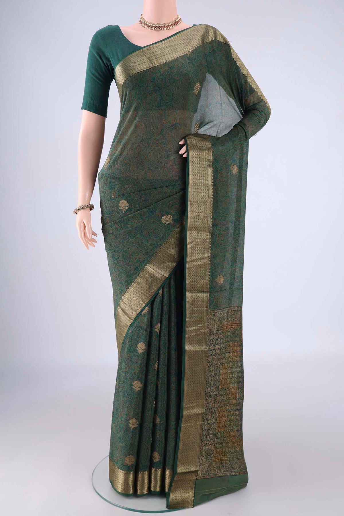 Bottle Green Crepe Saree with Floral Print on the body and Zari Border.  displayed on a mannequin