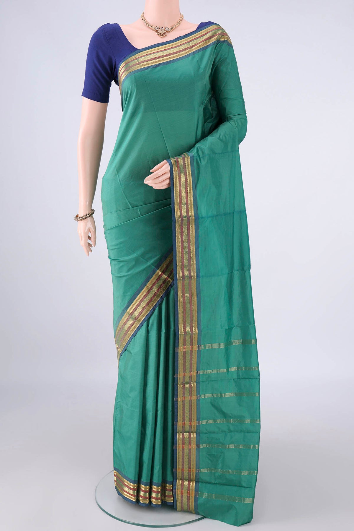 Sea Green Blended Bangalore Silk Saree with Plain Body and Zari Border.  displayed on a mannequin