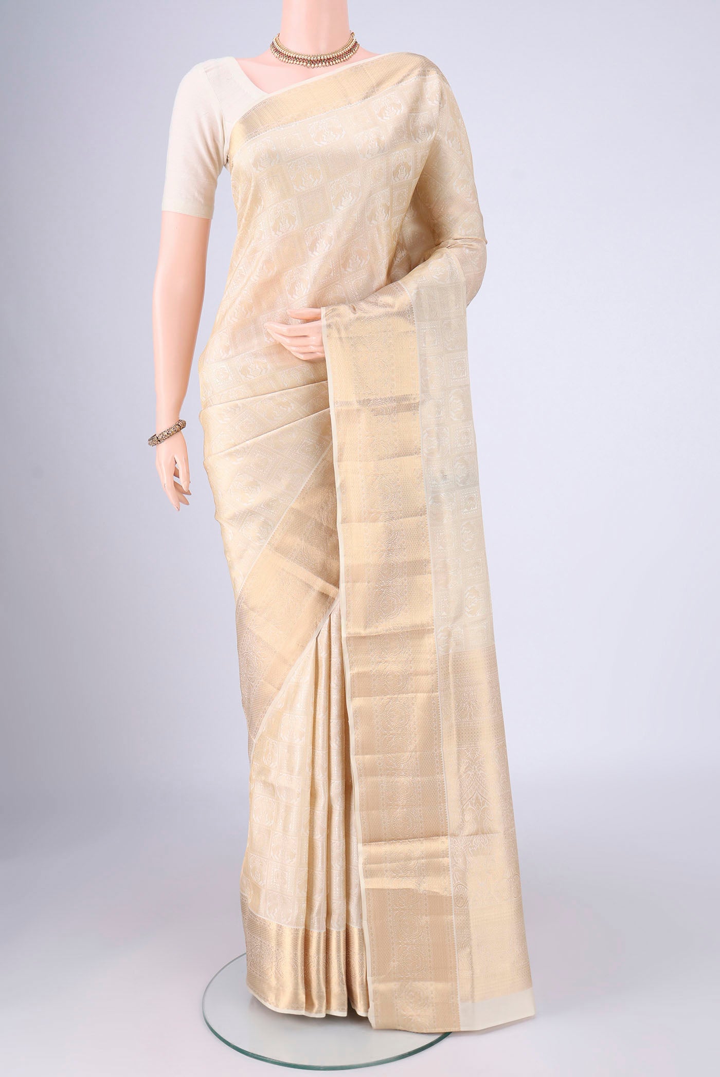 Off White Soft Silk Saree with Zari Brocade on the body and Zari Border.  displayed on a mannequin