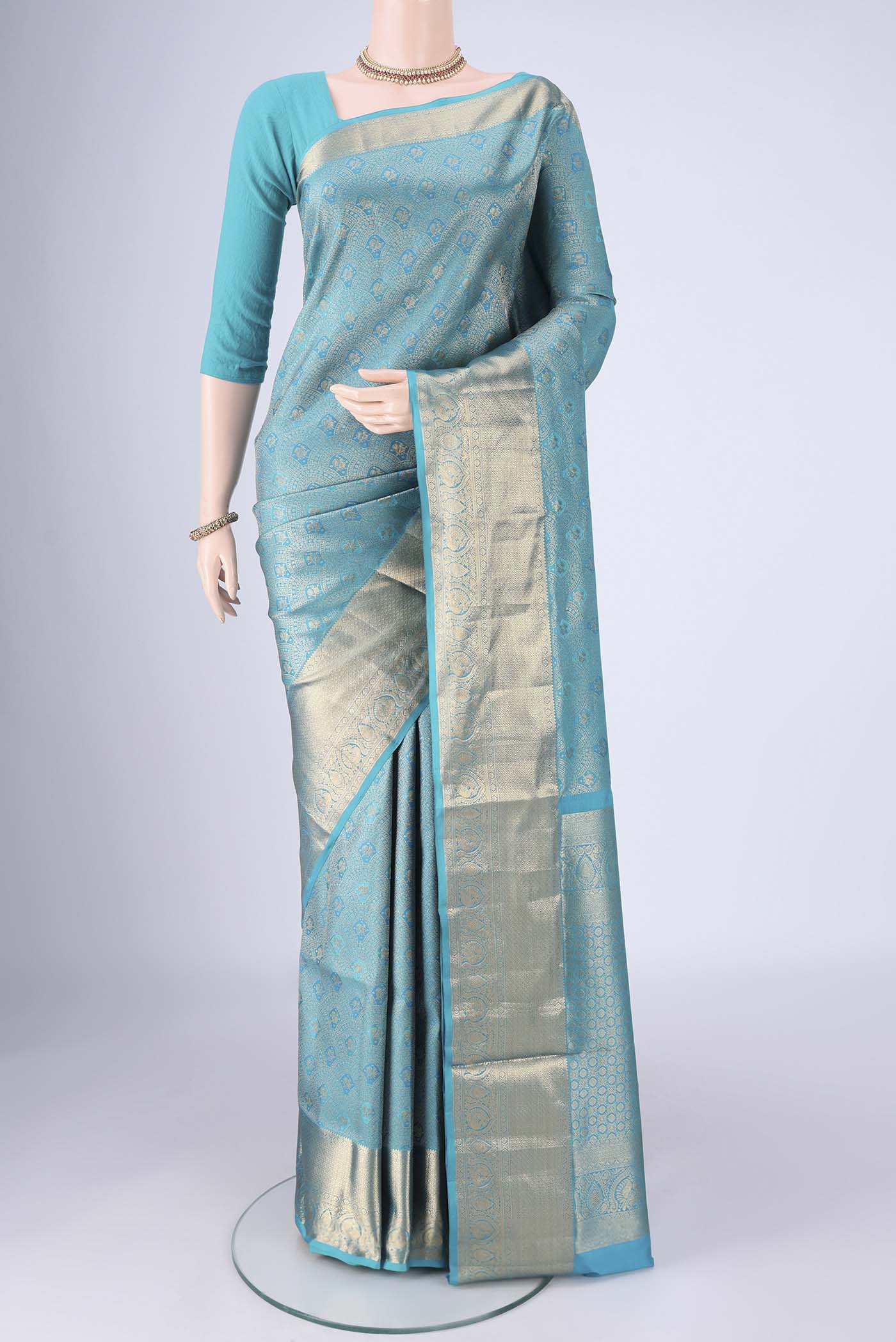 Turquoise Soft Silk Saree with Zari Brocade on the body and Zari Border.  displayed on a mannequin