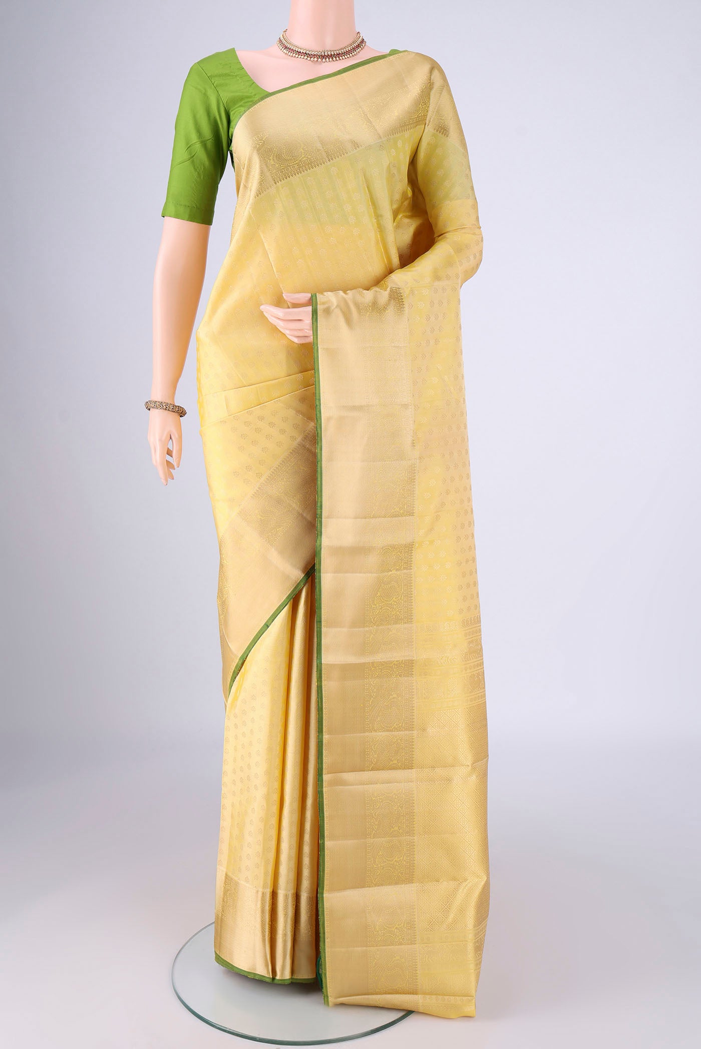Lemon Yellow Kanchipuram Silk Saree with Jacquard design on the body and Zari Border.  displayed on a mannequin