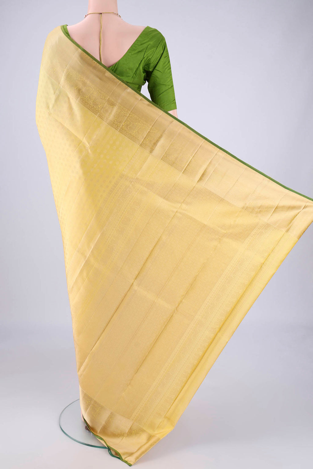 Flat view of Lemon Yellow Kanchipuram Silk Saree with Jacquard design on the body and Zari Border. 