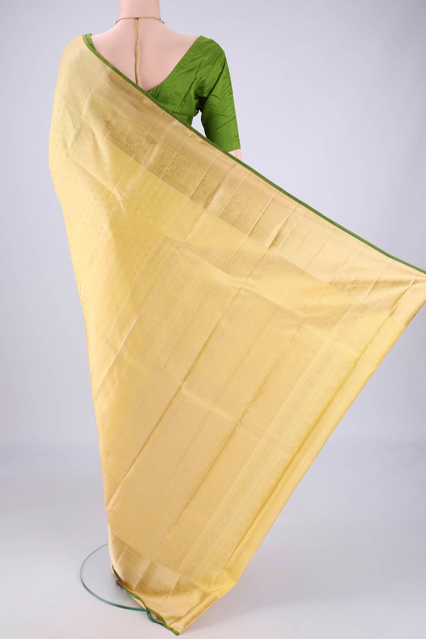 Flat view of Lemon Yellow Kanchipuram Silk Saree with Jacquard design on the body and Zari Border. 