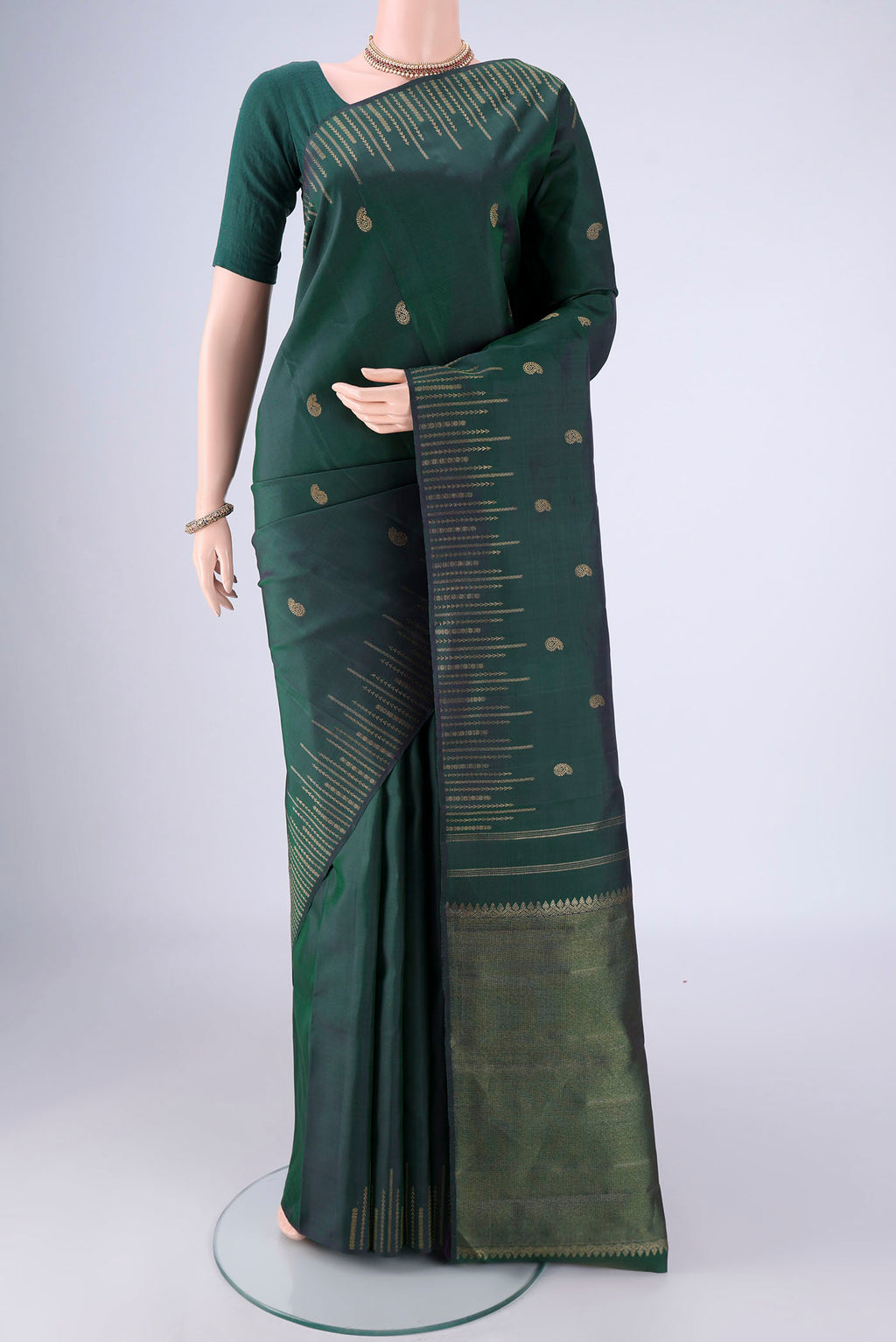 Pure Silk Pure Zari Bottle Green Kanchipuram Saree with Zari Butta on the body and Zari Border.  displayed on a mannequin