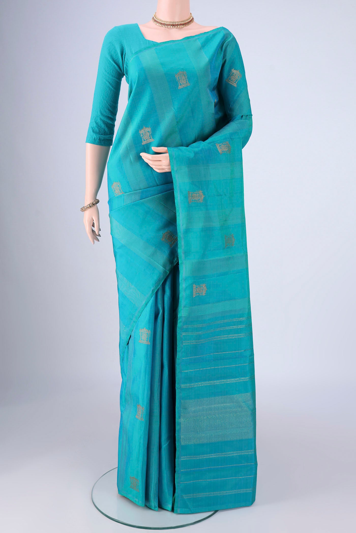 Pure Silk Pure Zari Turquoise Kanjivaram Saree with Zari Butta on the body and Without Border.  displayed on a mannequin