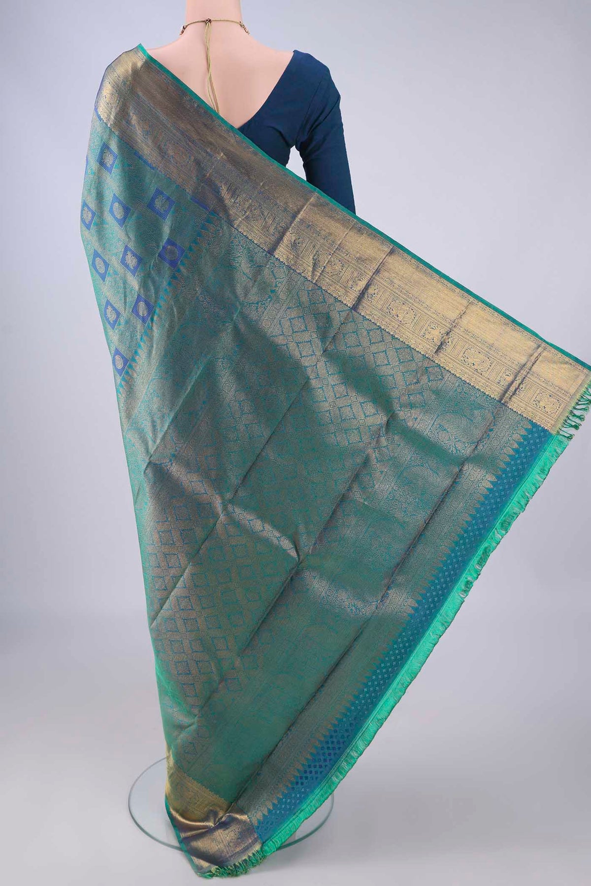Flat view of Peacock Blue Dual Tone Kanchipuram Silk Saree with Zari Brocade on the body and Zari Border. 