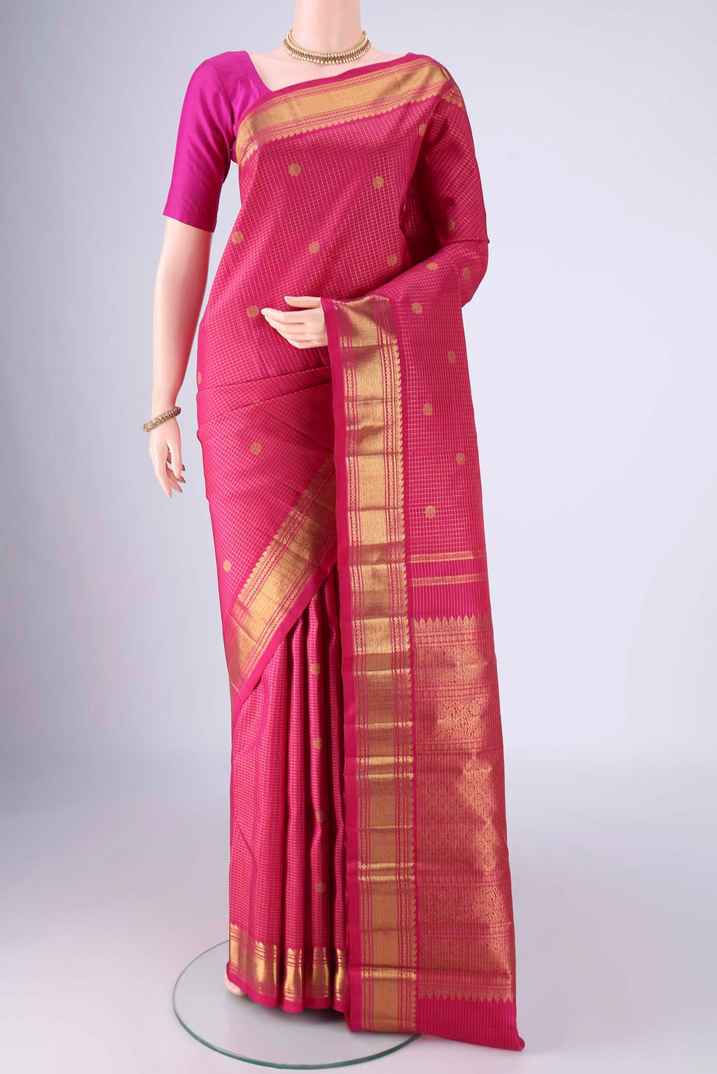 Rani Pink Kanchipuram Silk Saree with Checked design on the body and Zari Border.  displayed on a mannequin