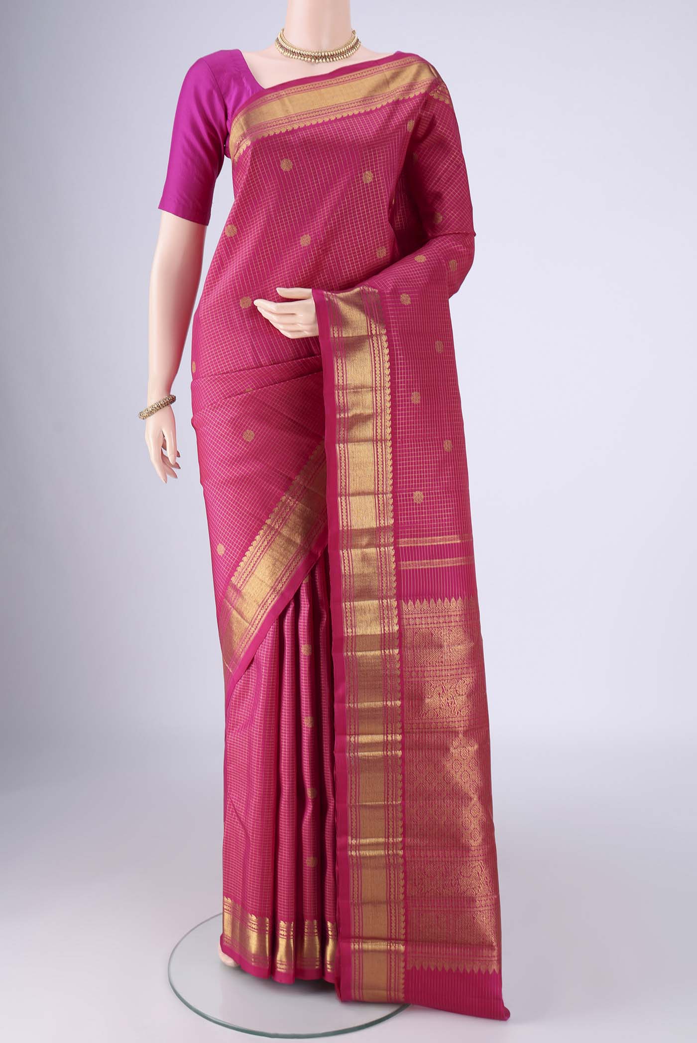 Rani Pink Kanchipuram Silk Saree with Checked design on the body and Zari Border.  displayed on a mannequin