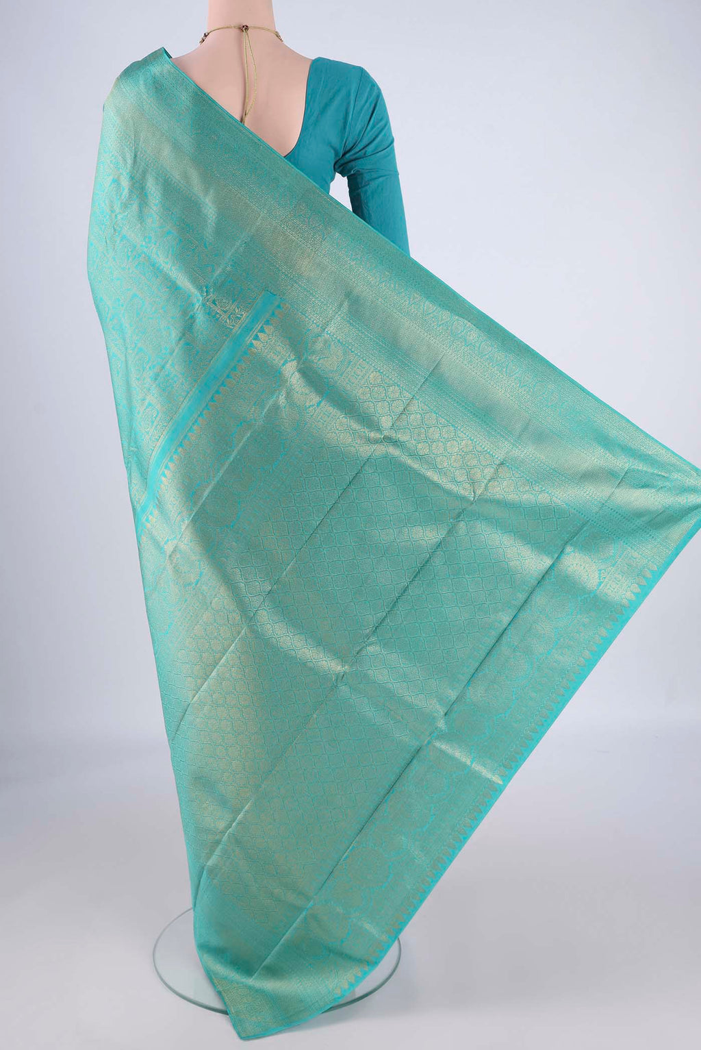 Flat view of Turquoise Kanchipuram Silk Saree with Zari Brocade on the body and Zari Border. 