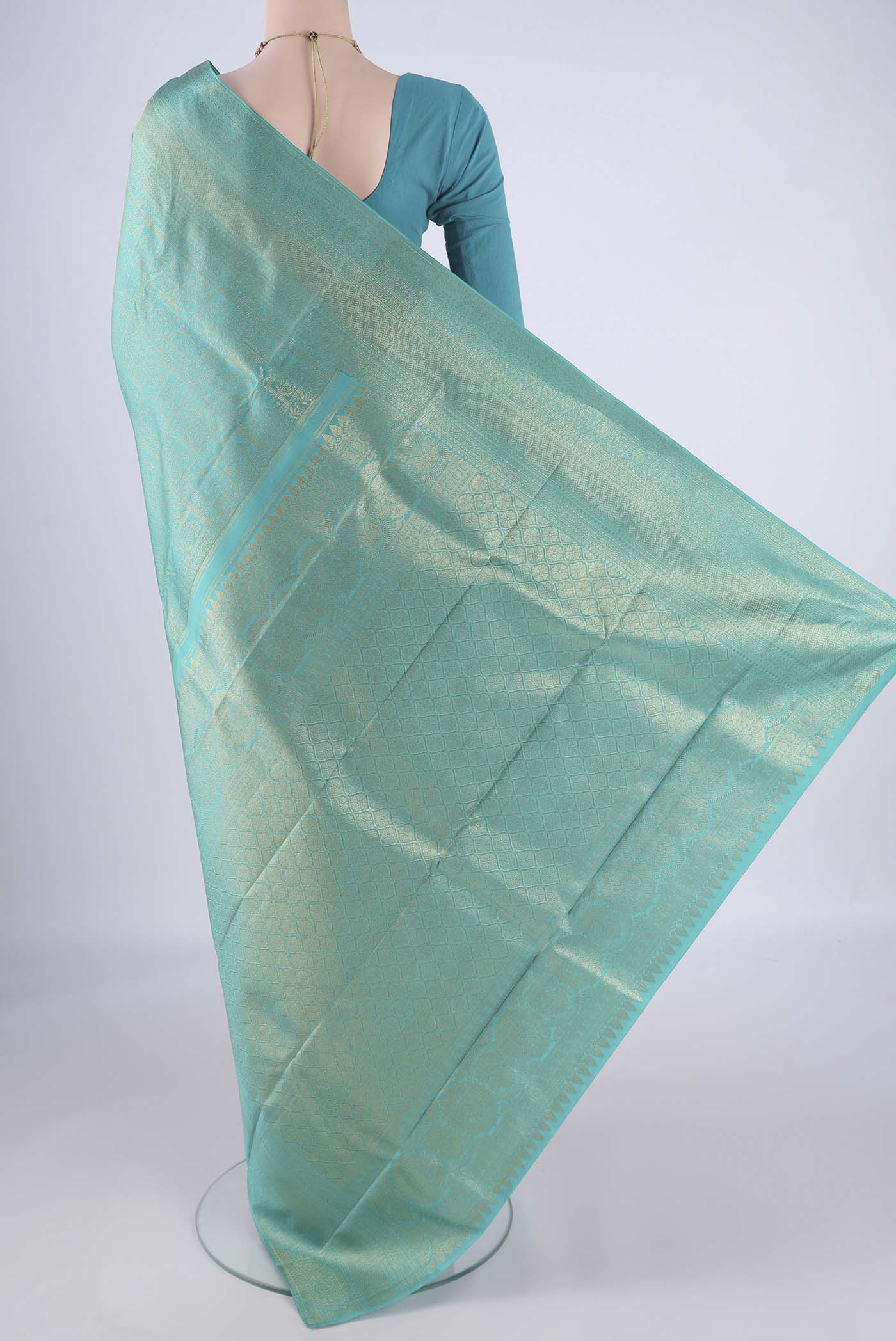 Flat view of Turquoise Kanchipuram Silk Saree with Zari Brocade on the body and Zari Border. 