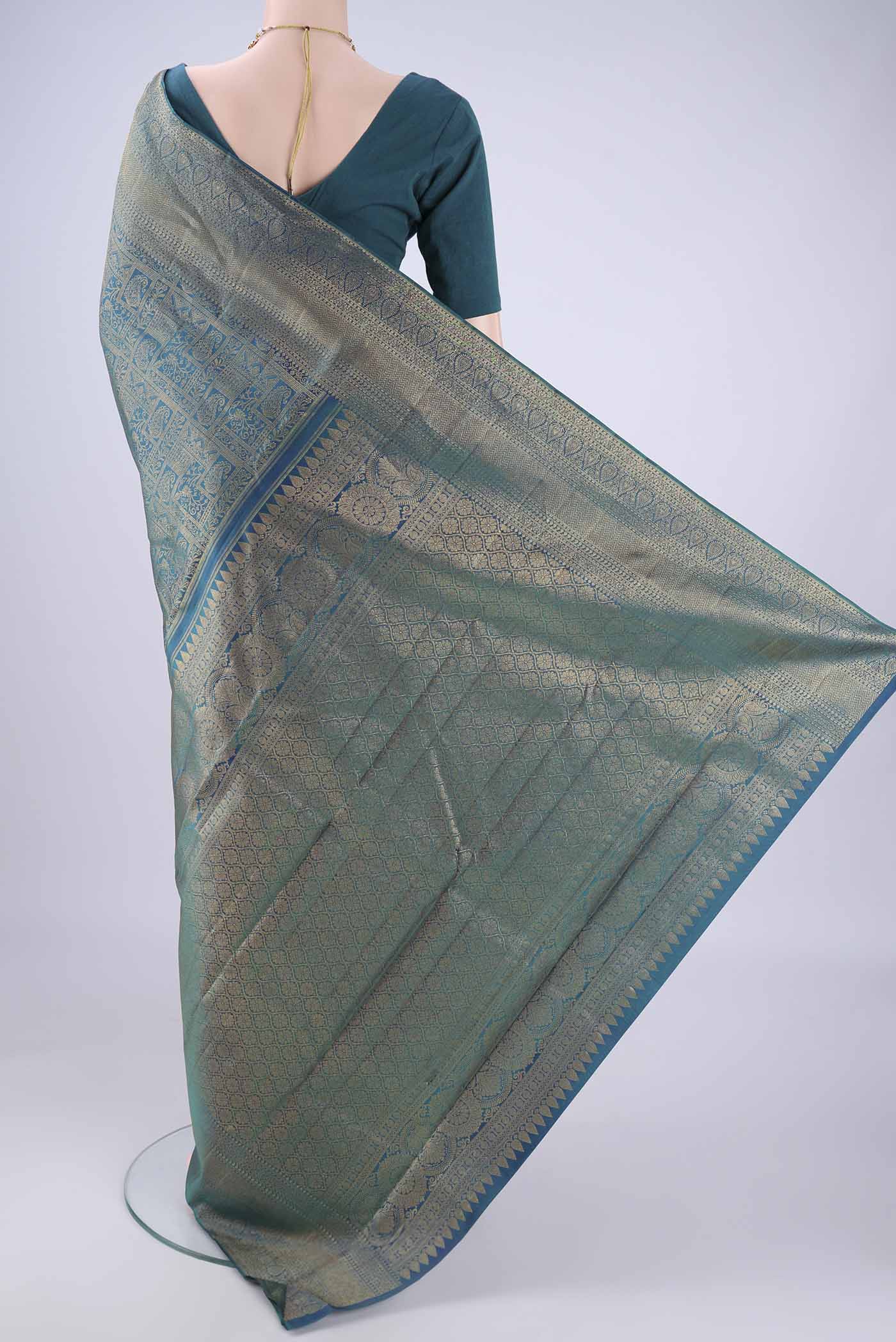 Flat view of Peacock Blue Kanchipuram Silk Saree with Zari Brocade on the body and Zari Border. 
