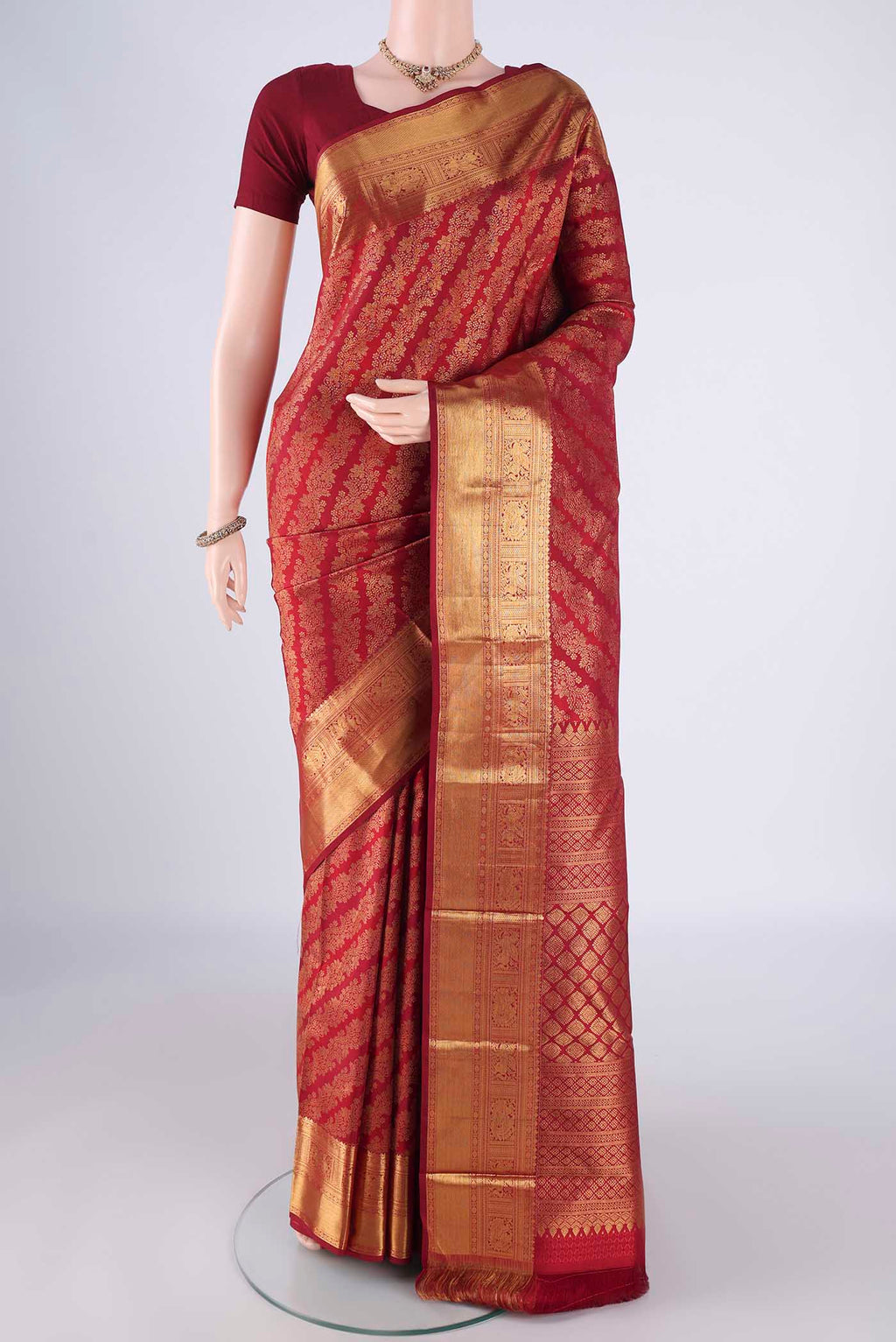 Maroon Kanjivaram Silk Saree with Zari Brocade on the body and Zari Border.  displayed on a mannequin