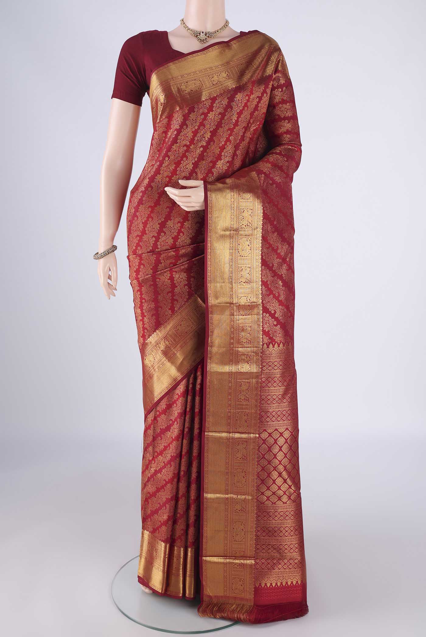 Maroon Kanjivaram Silk Saree with Zari Brocade on the body and Zari Border.  displayed on a mannequin