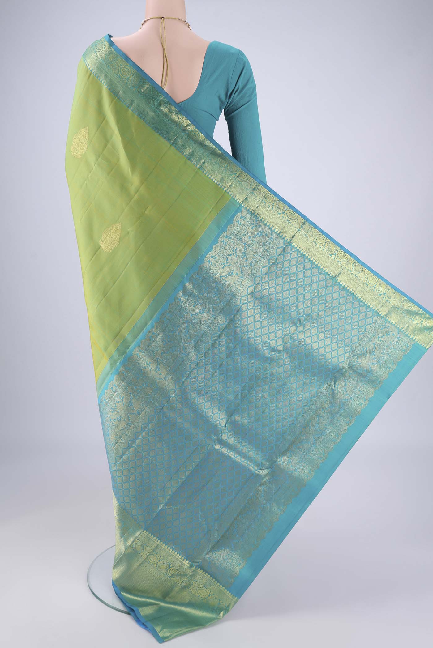 Flat view of Green Kanchipuram Silk Saree with Zari Butta on the body and Zari Border. 