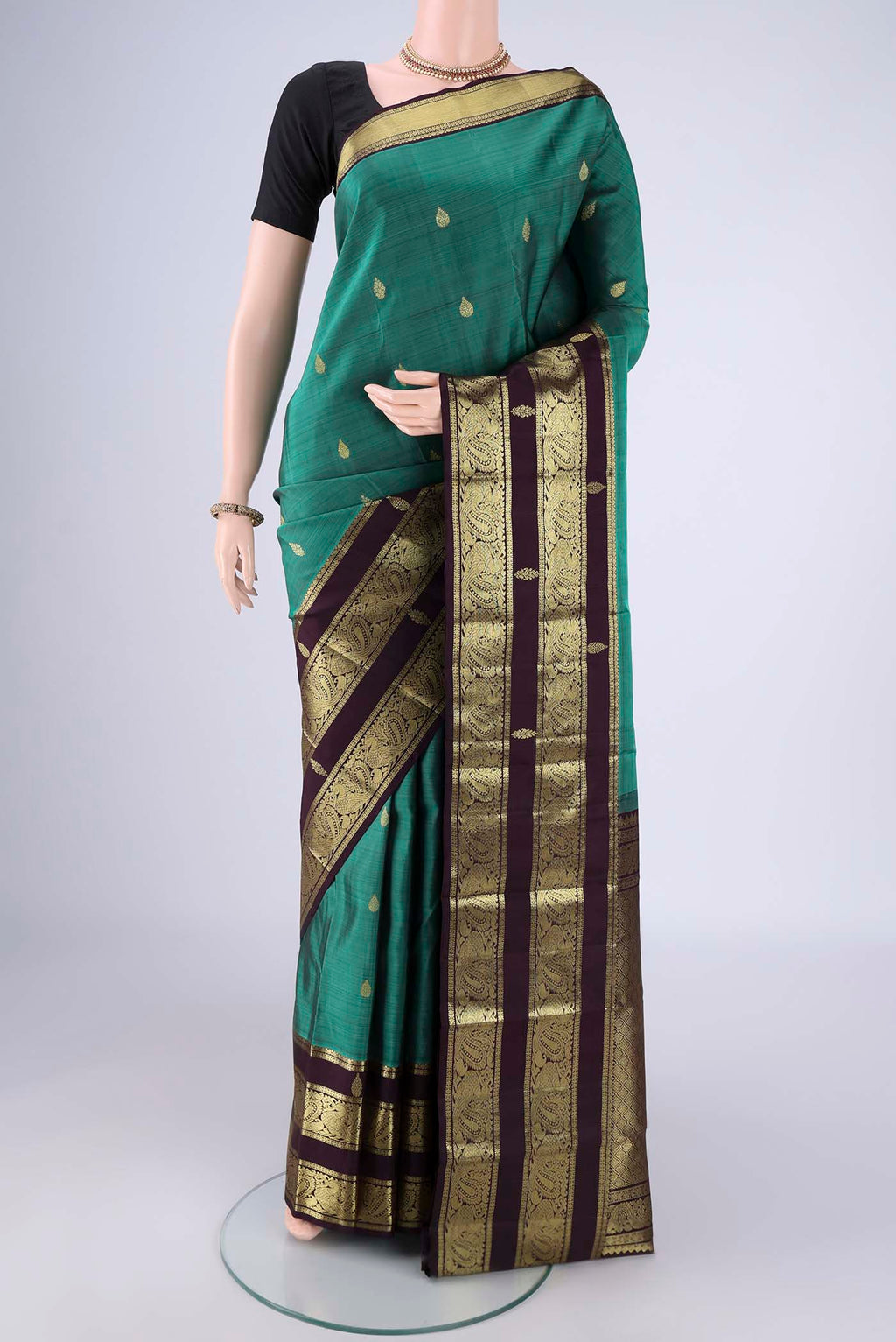 Sea Green Kanchipuram Silk Saree with Zari Butta on the body and Zari Border.  displayed on a mannequin