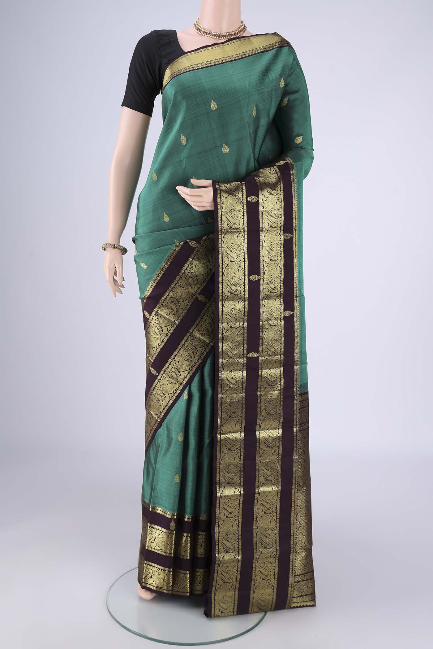 Sea Green Kanchipuram Silk Saree with Zari Butta on the body and Zari Border.  displayed on a mannequin