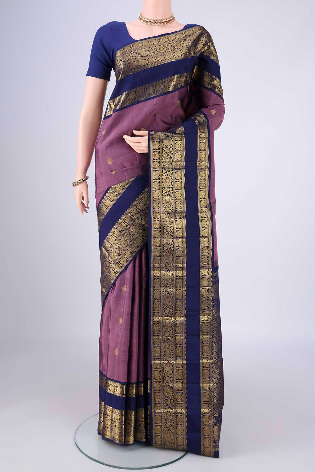 Dark Mauve Kanchipuram Silk Saree with Zari Butta on the body and Zari Border.  displayed on a mannequin