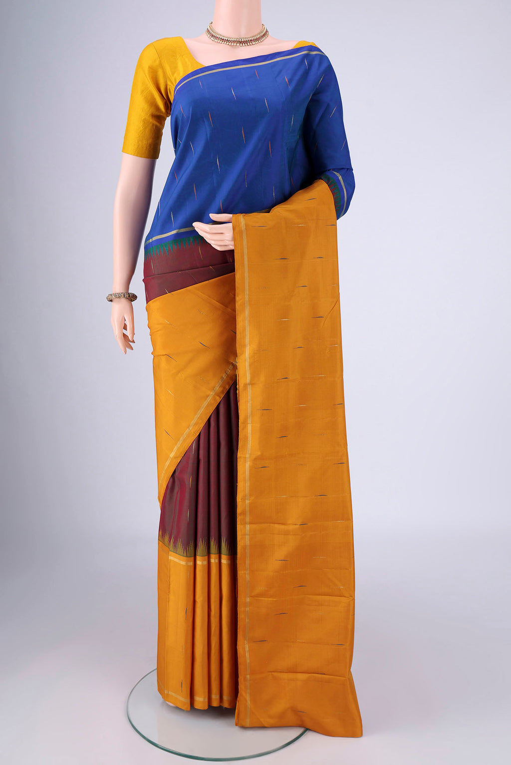 Maroon Kanjivaram Silk Saree with Zari And Thread Butta on the body and Ganga Jamuna Border.  displayed on a mannequin