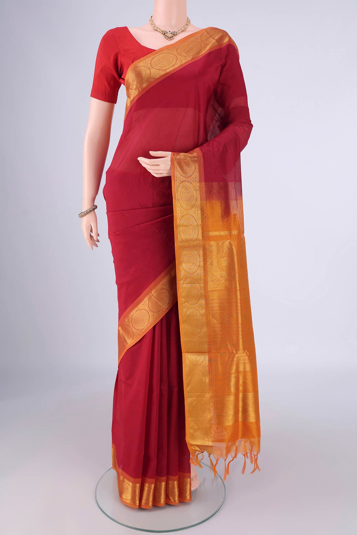 Maroon Silk Cotton Saree with Plain Body and Zari Border.  displayed on a mannequin