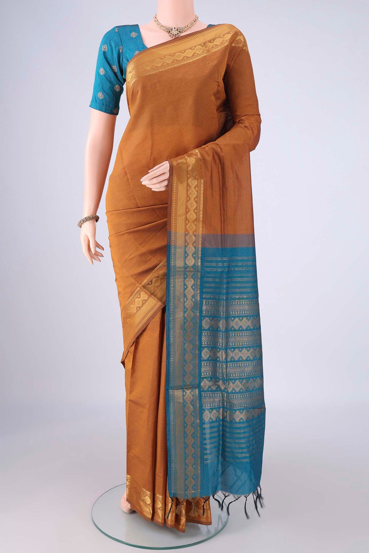 Mustard Blended Poly Cotton Saree with Plain Body and Zari Border.  displayed on a mannequin