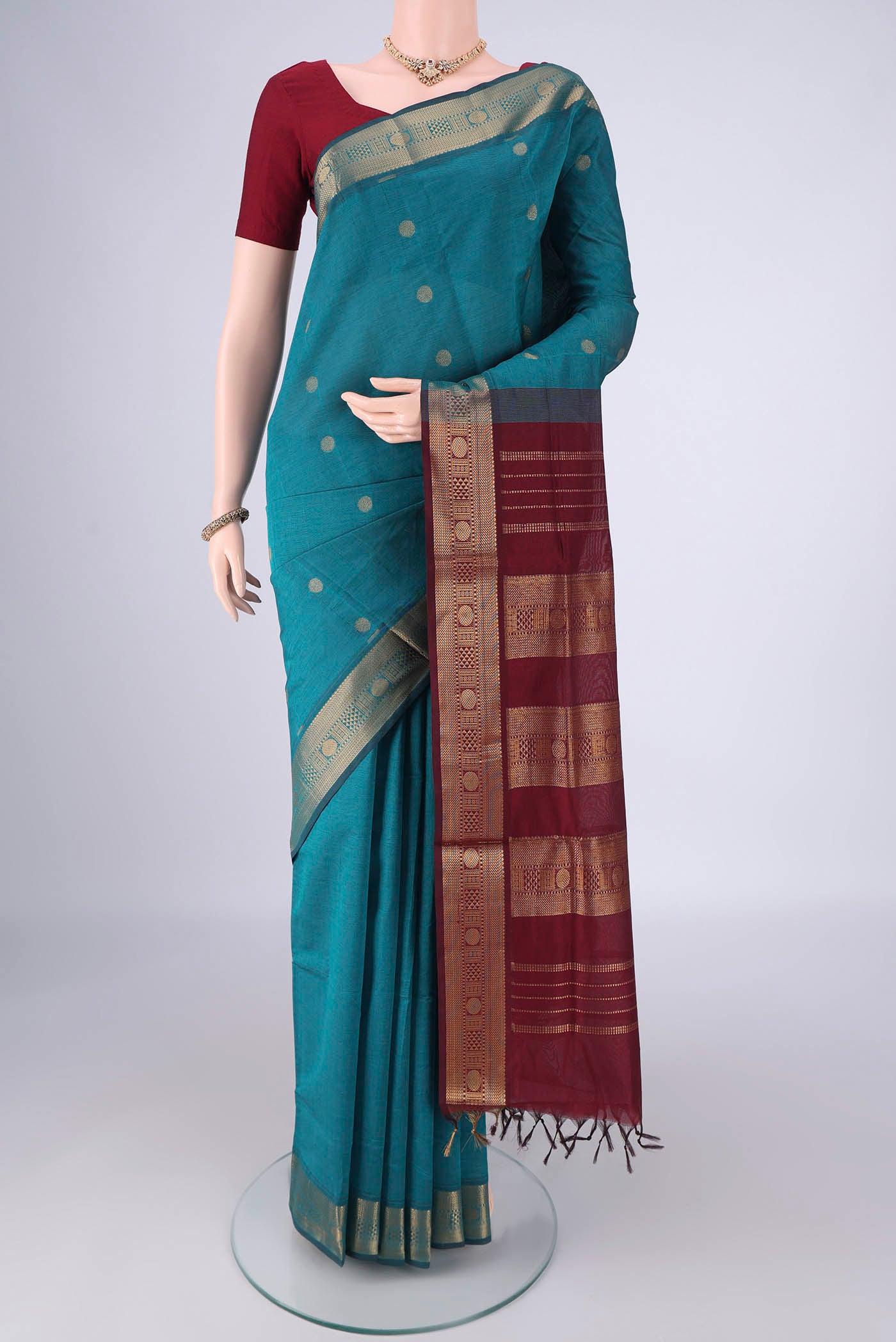 Teal Blended Poly Cotton Saree with Zari Butta on the body and Zari Border.  displayed on a mannequin