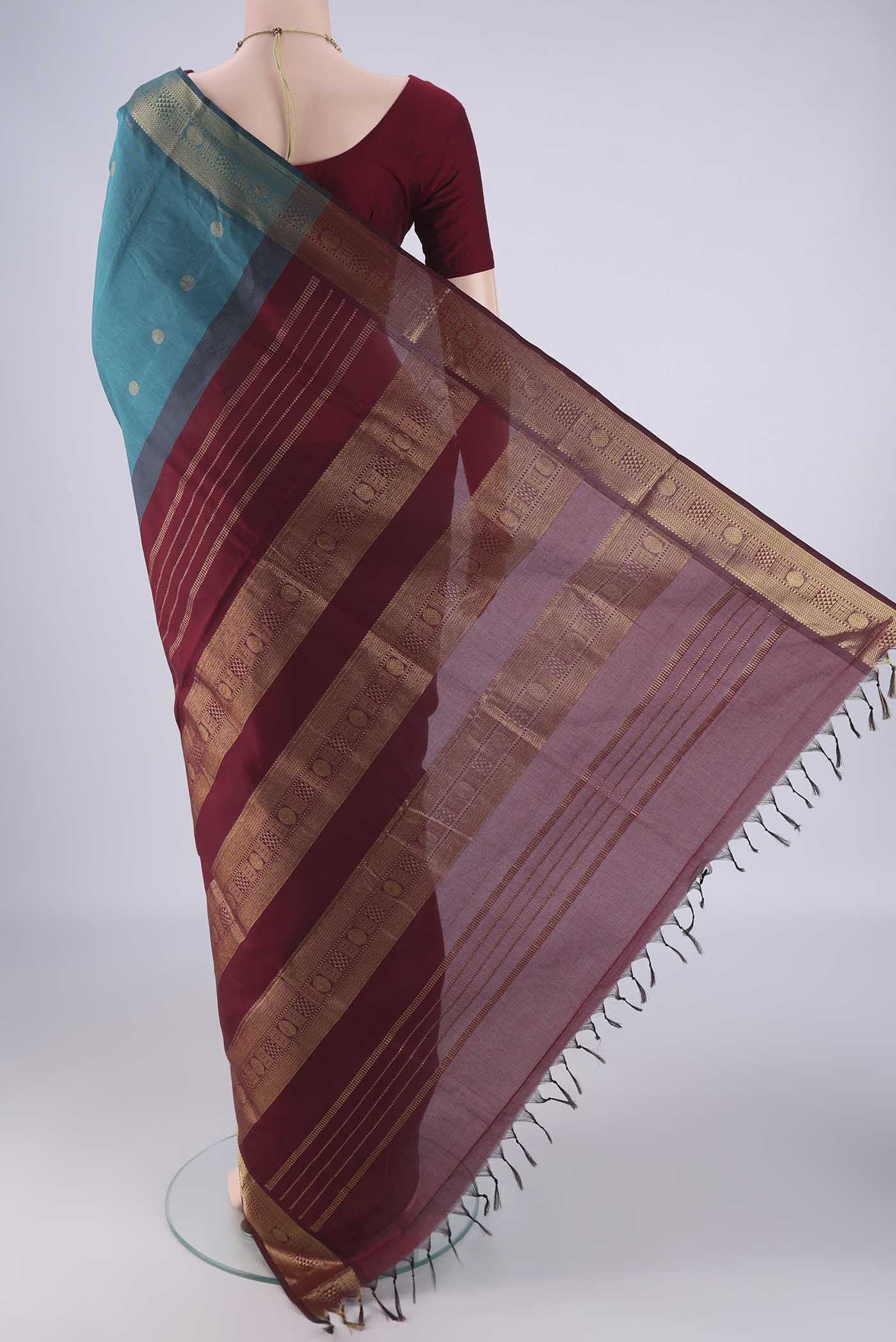 Flat view of Teal Blended Poly Cotton Saree with Zari Butta on the body and Zari Border. 