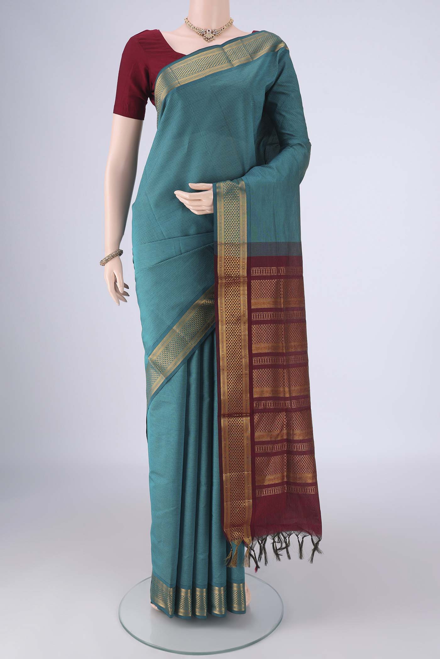 Teal Blended Poly Cotton Saree with Stripes on the body and Zari Border.  displayed on a mannequin