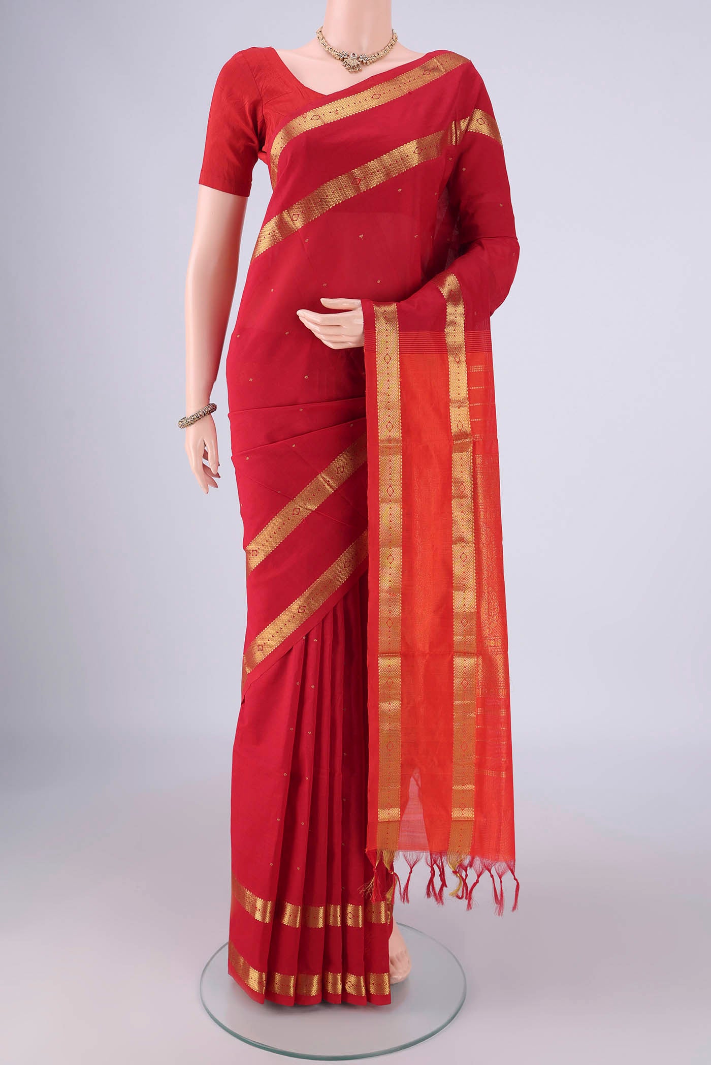 Red Blended Poly Cotton Saree with Zari Butta on the body and Zari Border.  displayed on a mannequin