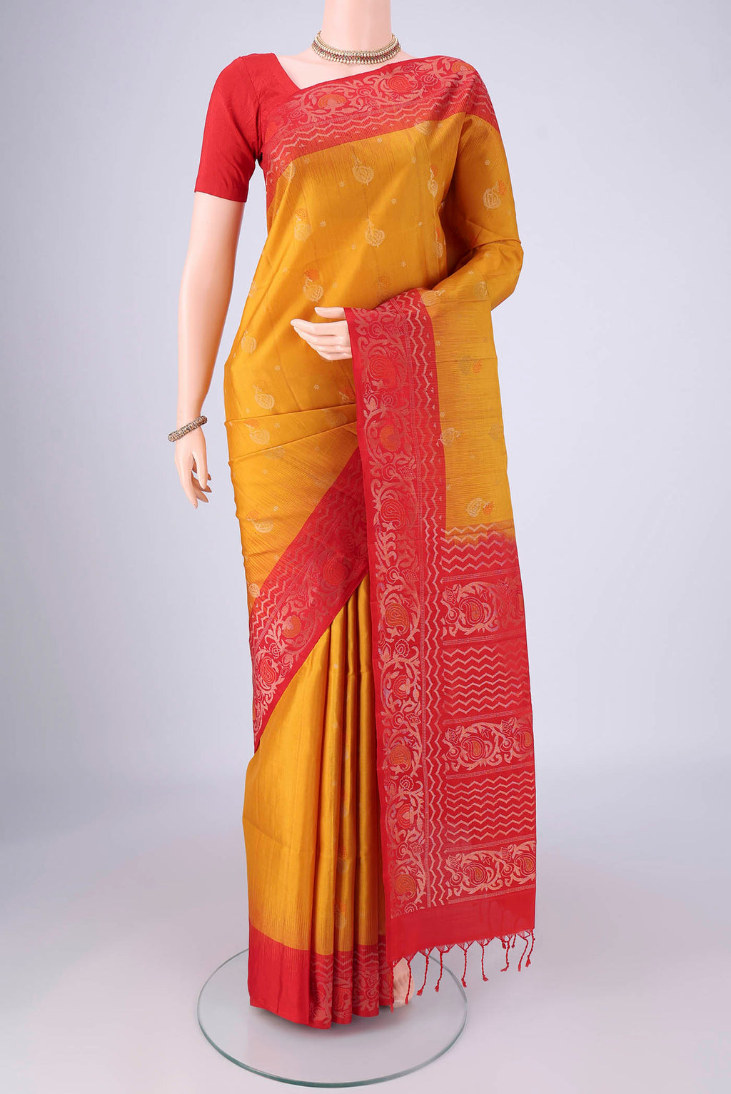 Mustard Soft Silk Saree with Zari Butta on the body and Zari Border.  displayed on a mannequin