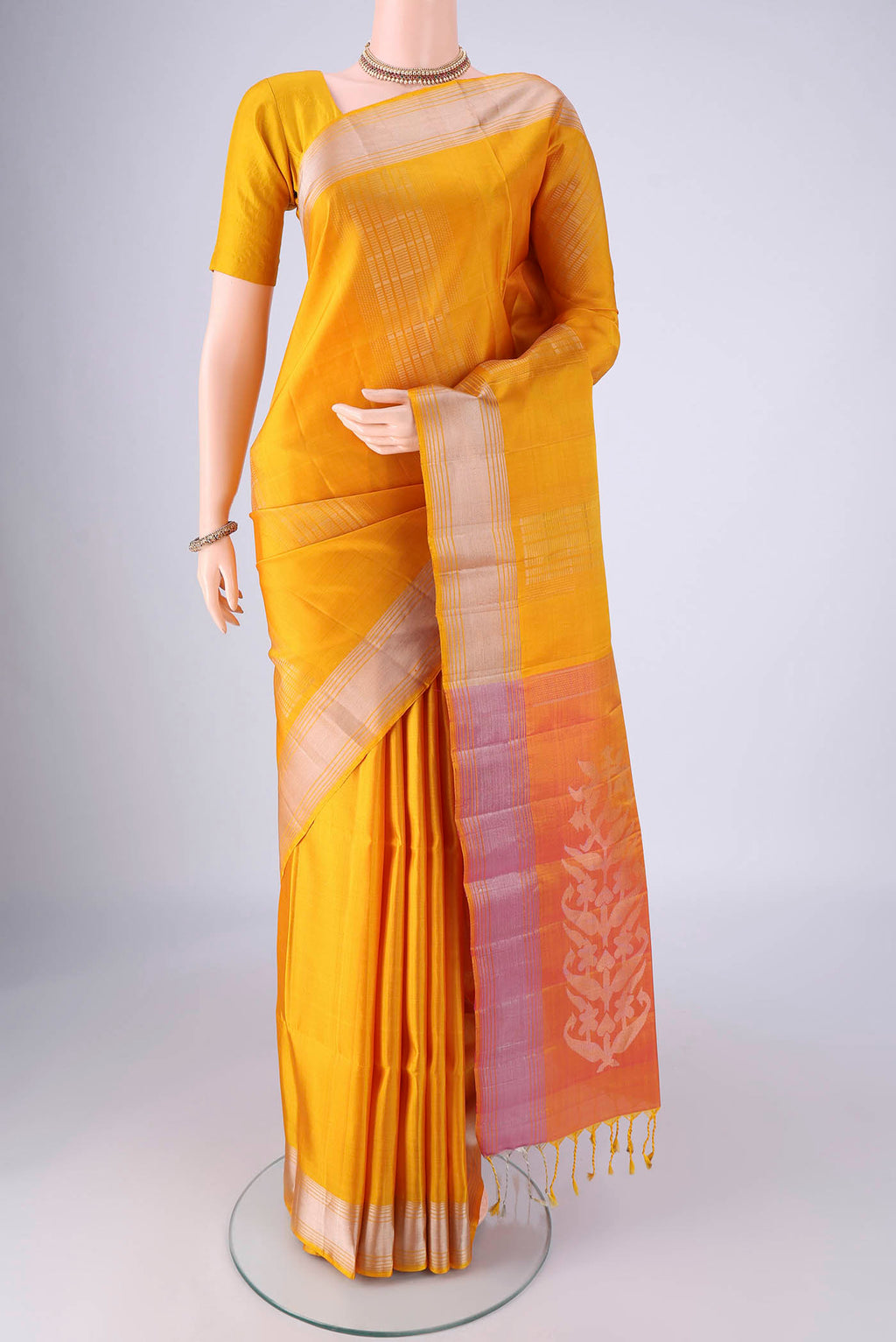 Yellow Soft Silk Saree with Zari Butta on the body and Zari Border.  displayed on a mannequin