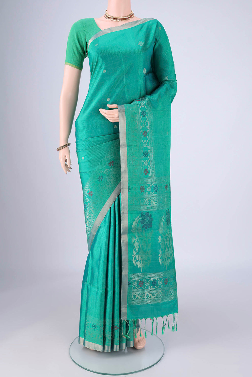Turquoise Soft Silk Saree with Zari Butta on the body and Zari Border.  displayed on a mannequin