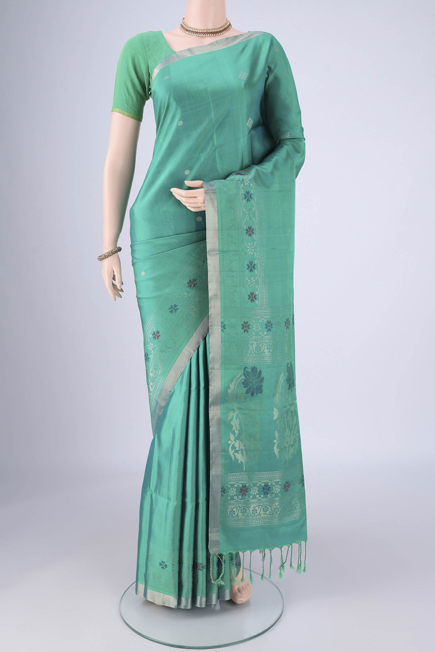 Turquoise Soft Silk Saree with Zari Butta on the body and Zari Border.  displayed on a mannequin