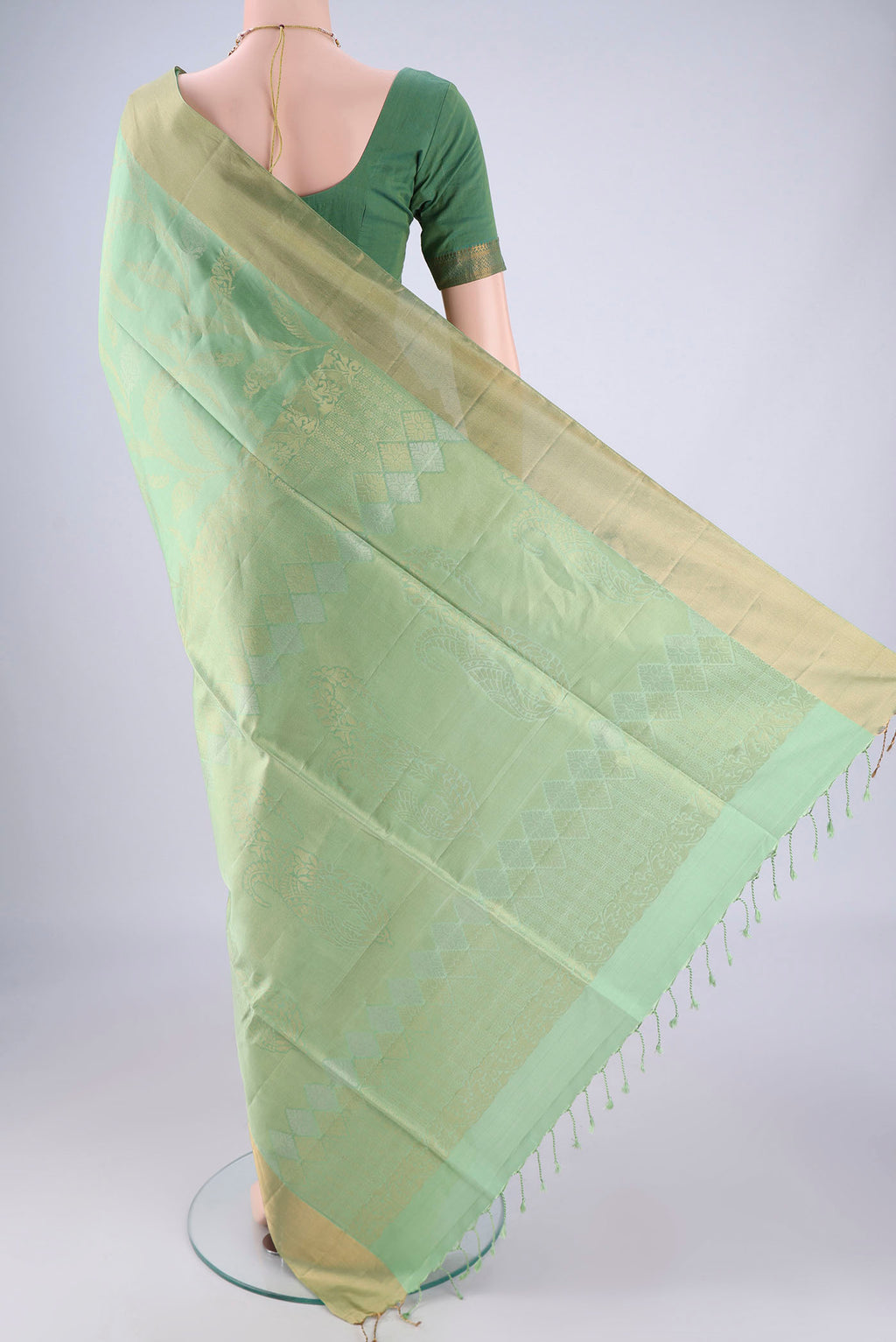 Flat view of Light Green Soft Silk Saree with Zari Butta on the body and Zari Border. 