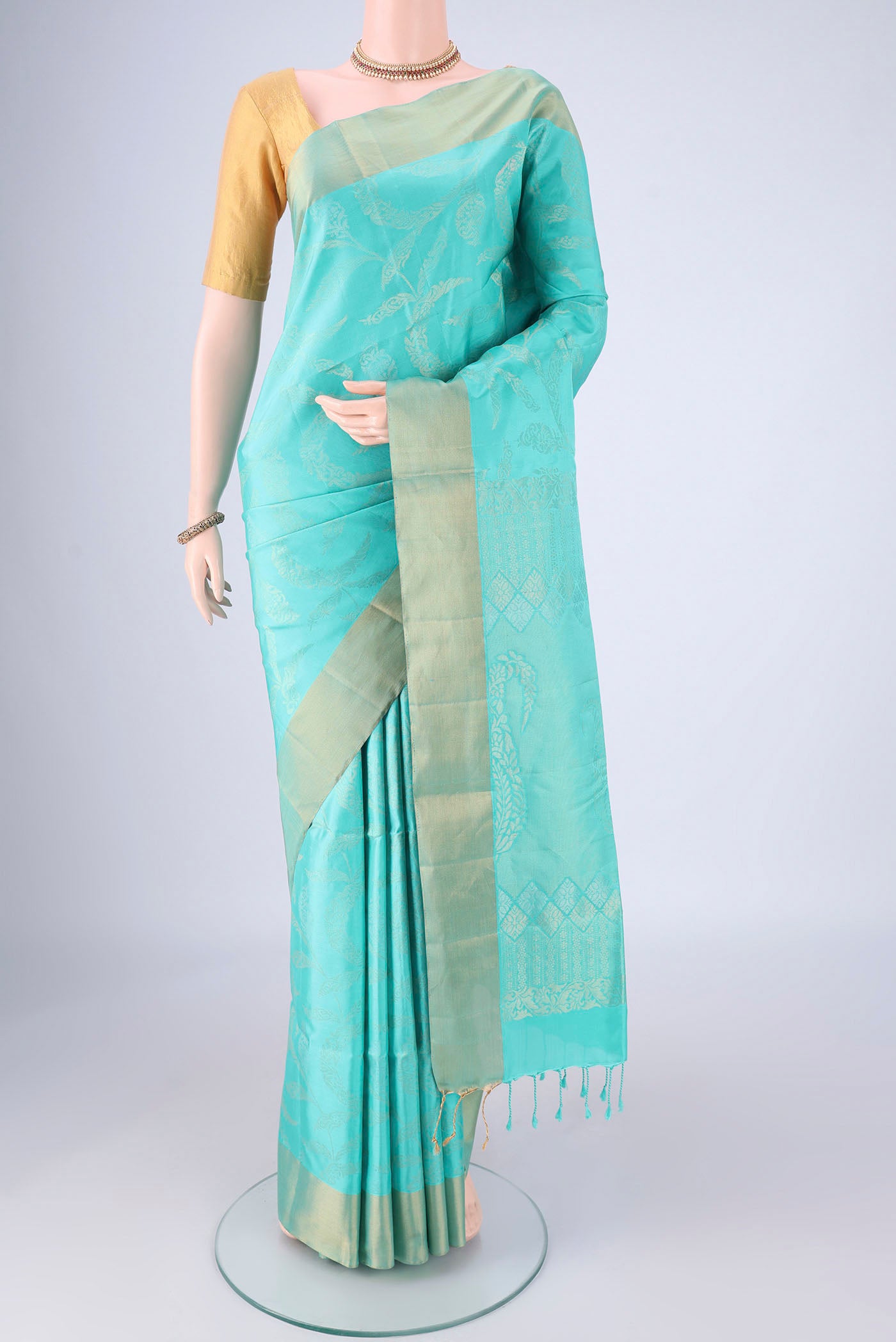 Turquoise Soft Silk Saree with Zari Butta on the body and Zari Border.  displayed on a mannequin