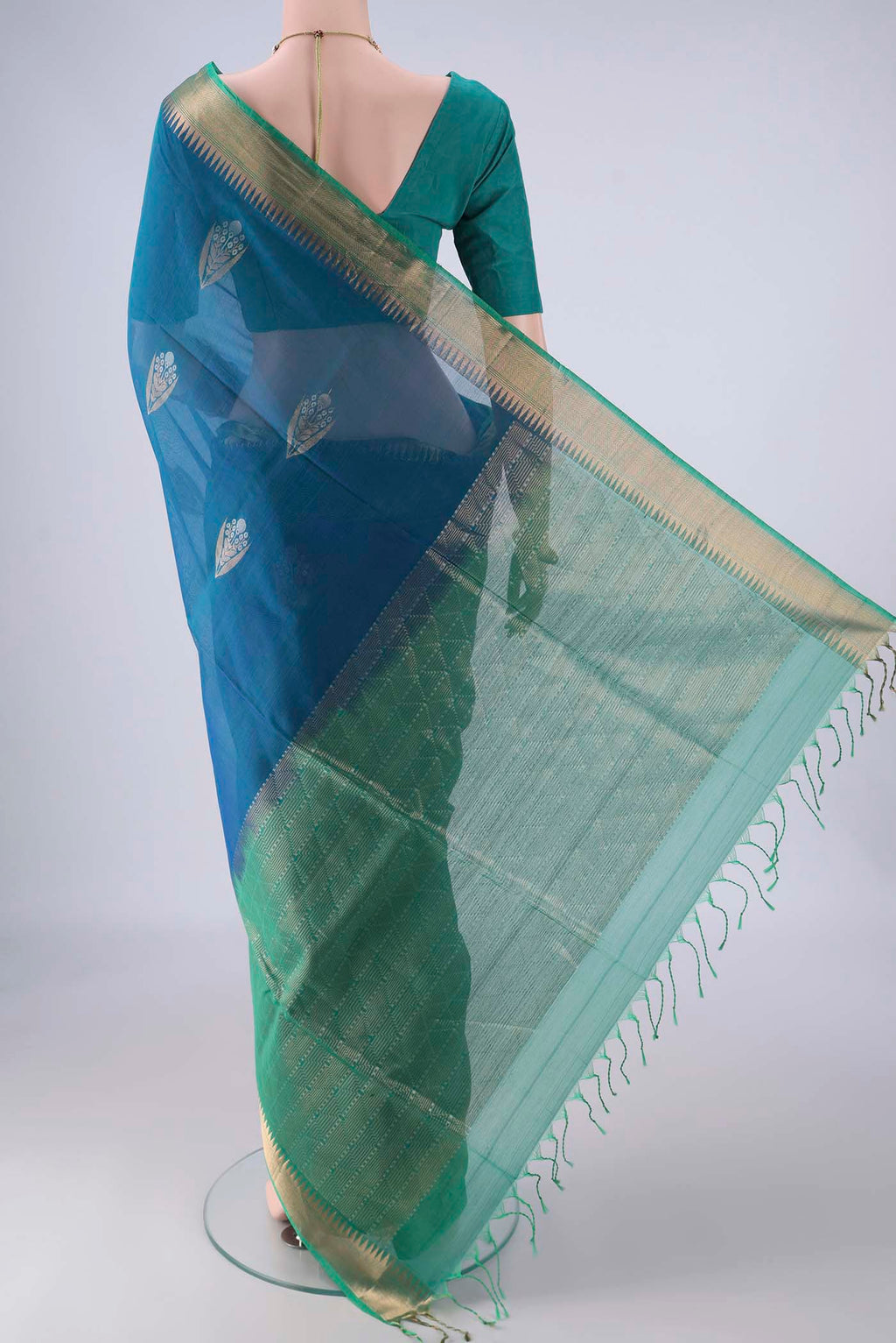 Flat view of Peacock Blue Kora Cotton Saree with Zari Butta on the body and Zari Border. 