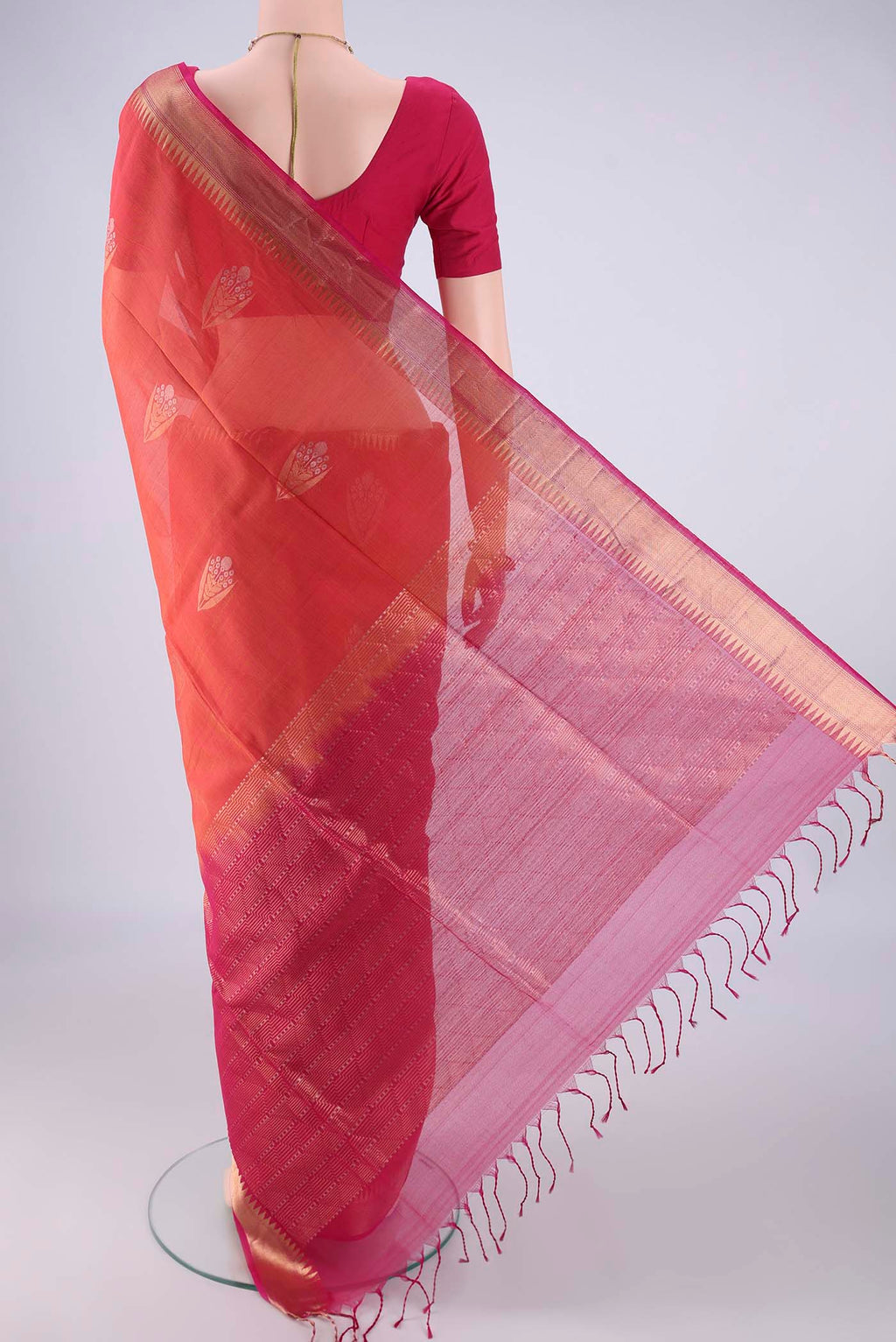 Flat view of Brick Orange Kora Cotton Saree with Zari Butta on the body and Zari Border. 