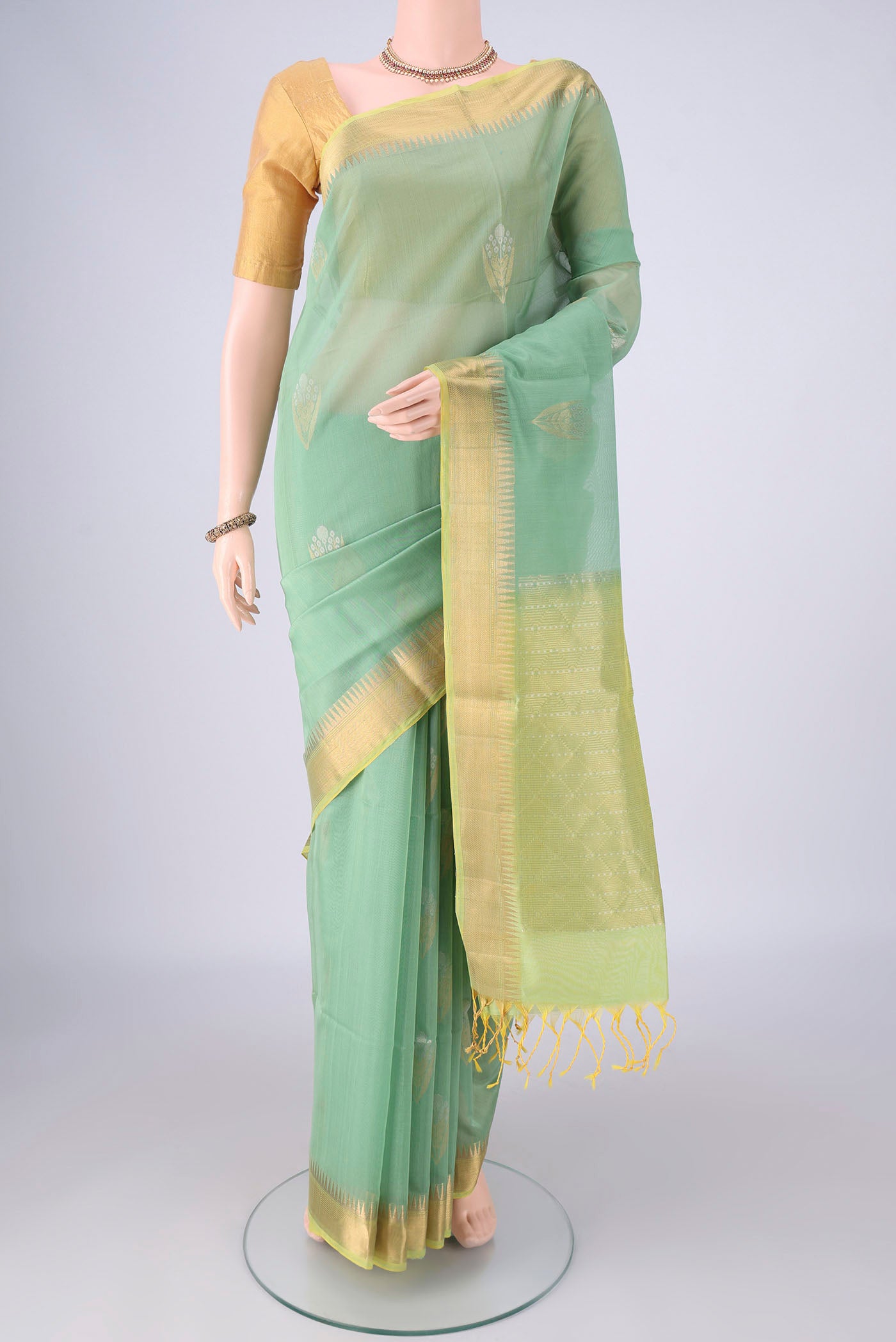Mint Green Silk Cotton Saree with Zari Butta on the body and Zari Border.  displayed on a mannequin