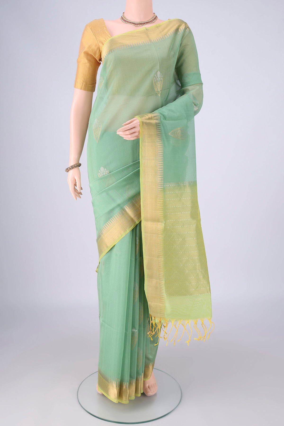 Mint Green Silk Cotton Saree with Zari Butta on the body and Zari Border.  displayed on a mannequin