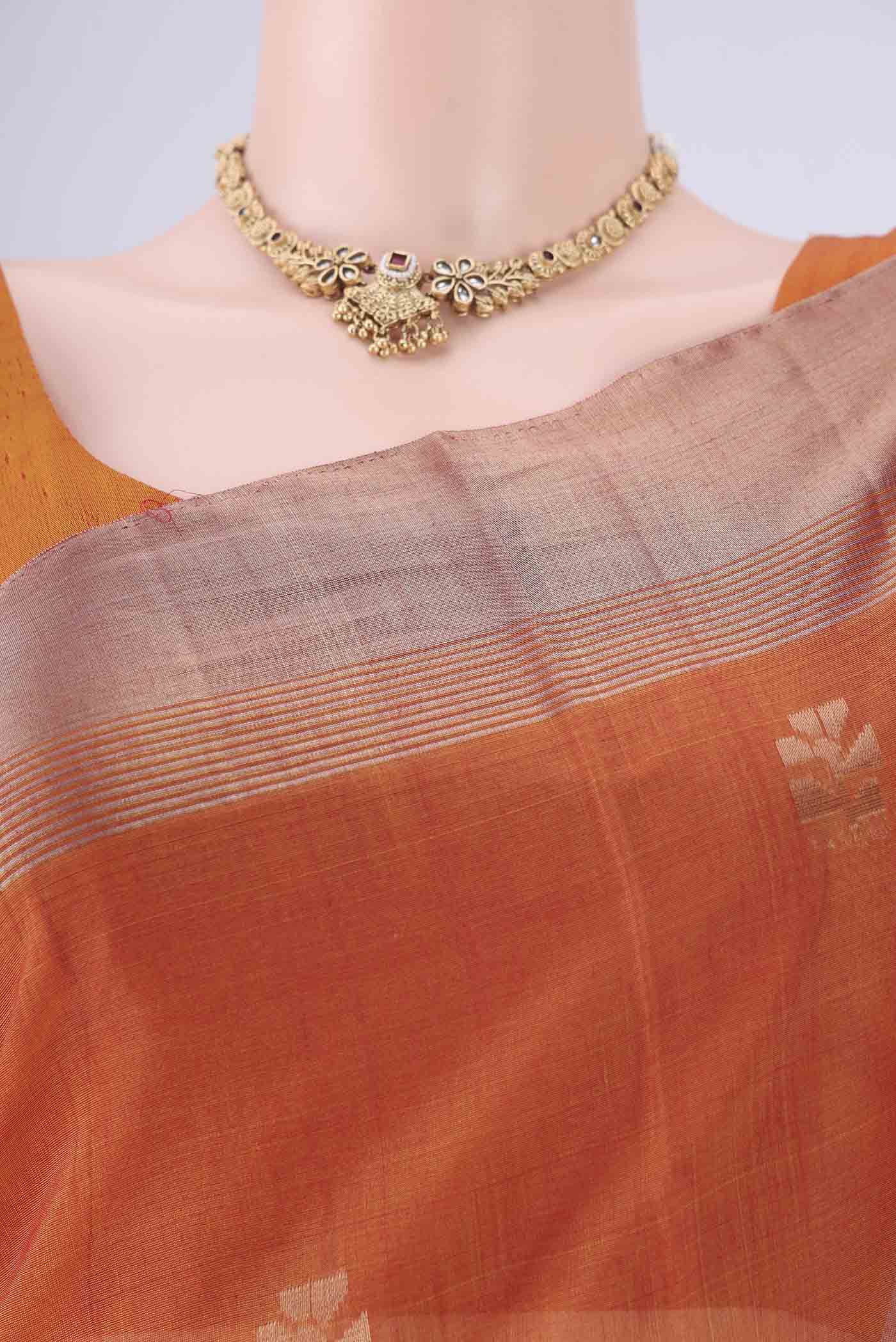 Border image of Rust Kora Cotton Saree with Zari Butta on the body and Zari Border. 