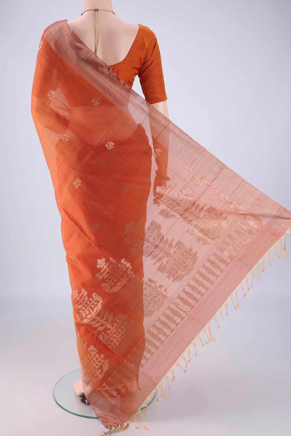 Flat view of Rust Kora Cotton Saree with Zari Butta on the body and Zari Border. 