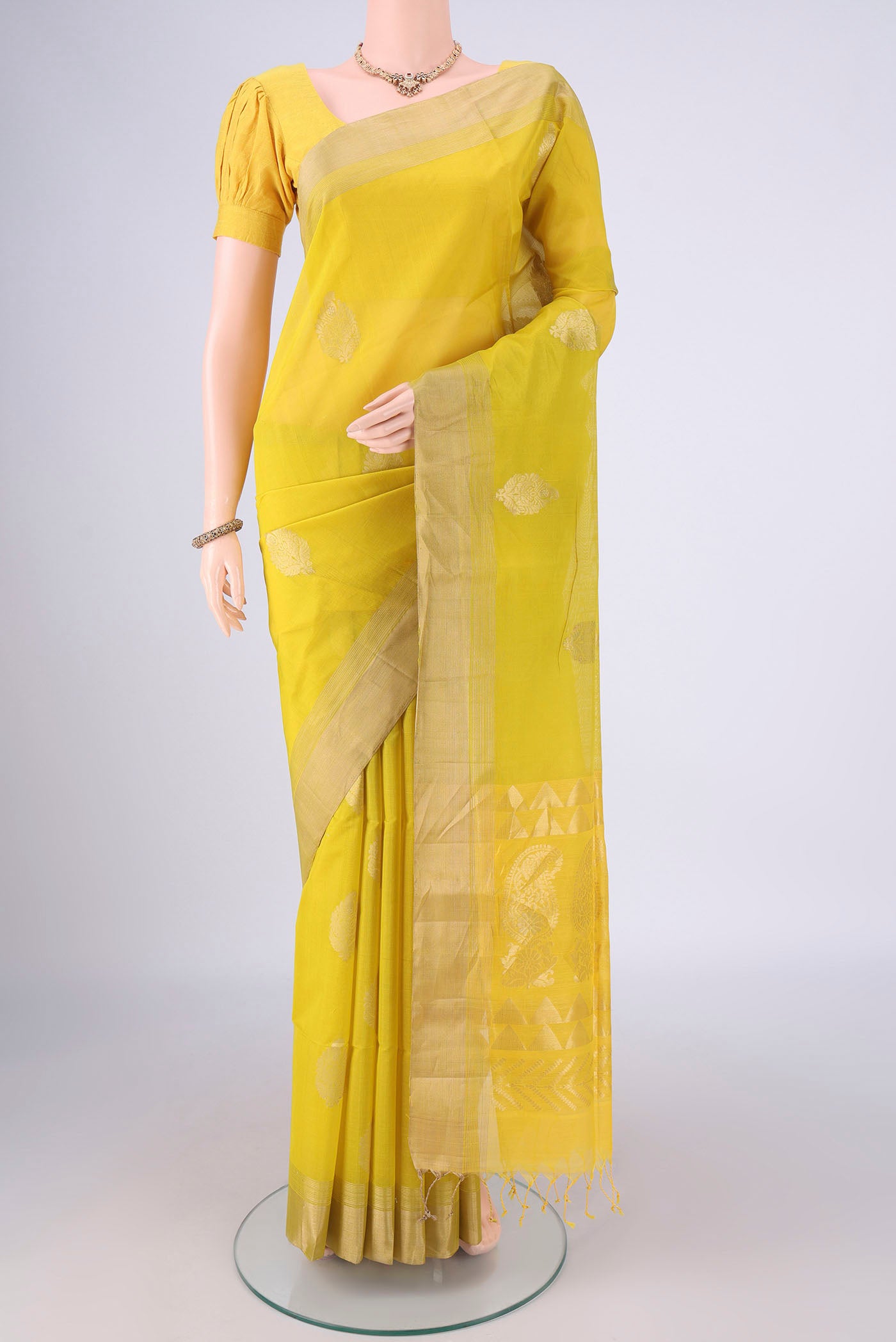 Yellow Silk Cotton Saree with Zari Butta on the body and Zari Border.  displayed on a mannequin