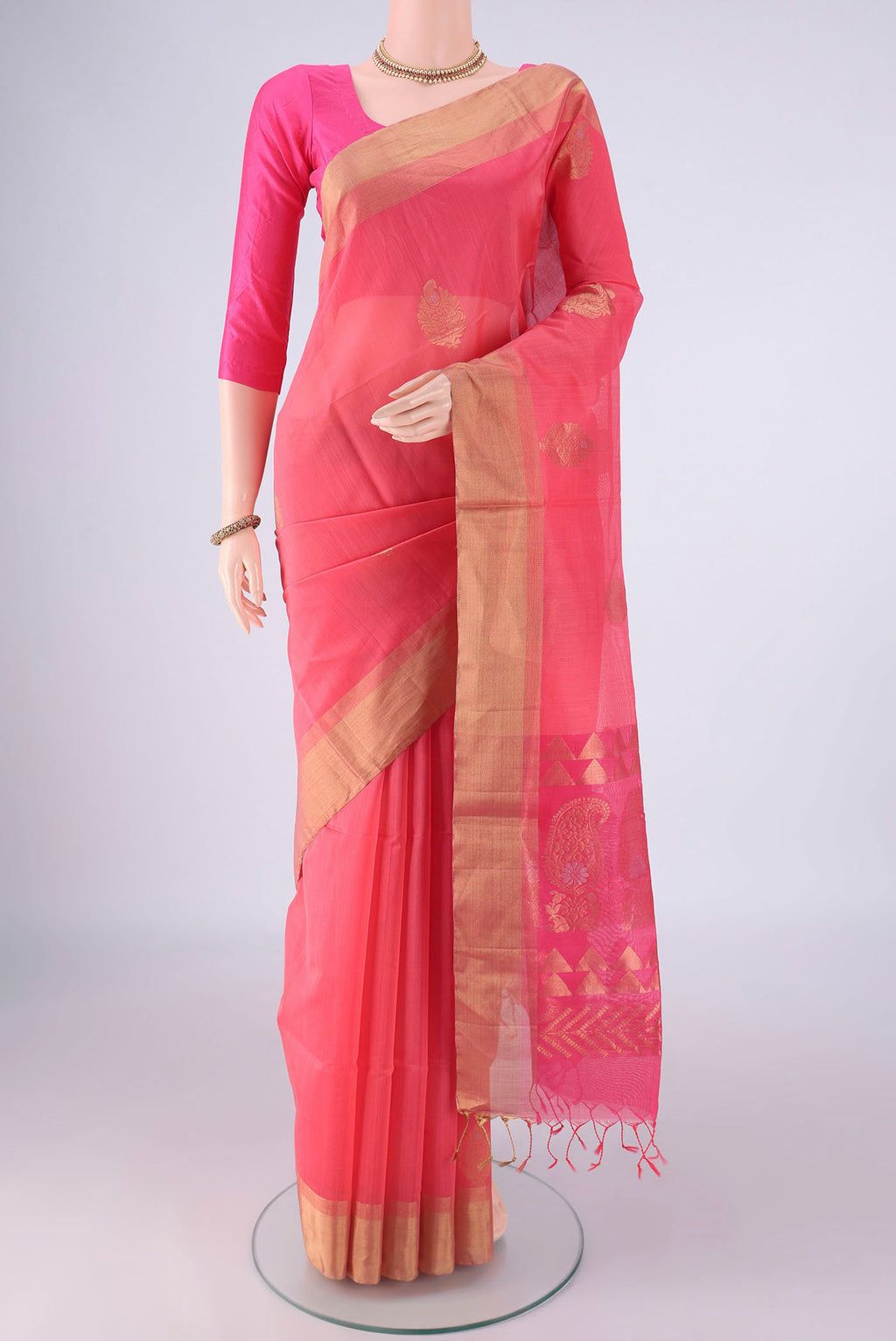 Peach Kora Cotton Saree with Zari Butta on the body and Zari Border.  displayed on a mannequin