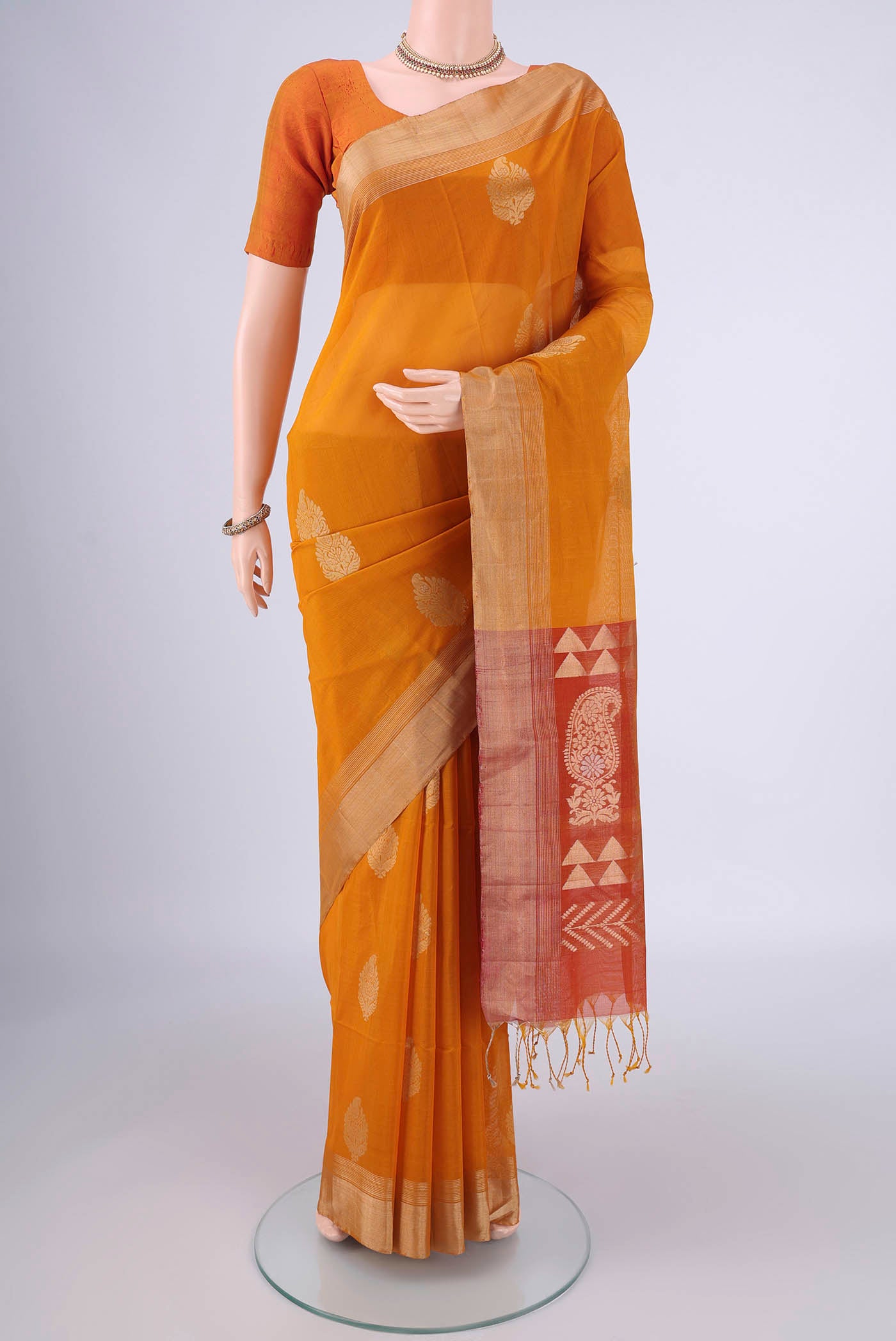 Mustard Silk Cotton Saree with Zari Butta on the body and Zari Border.  displayed on a mannequin