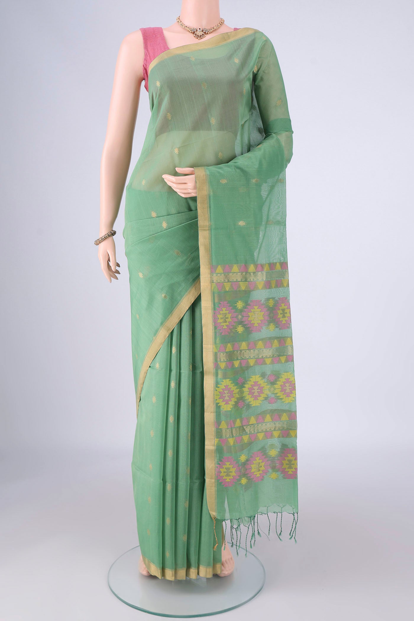 Light Green Kora Cotton Saree with Zari Butta on the body and Zari Border.  displayed on a mannequin