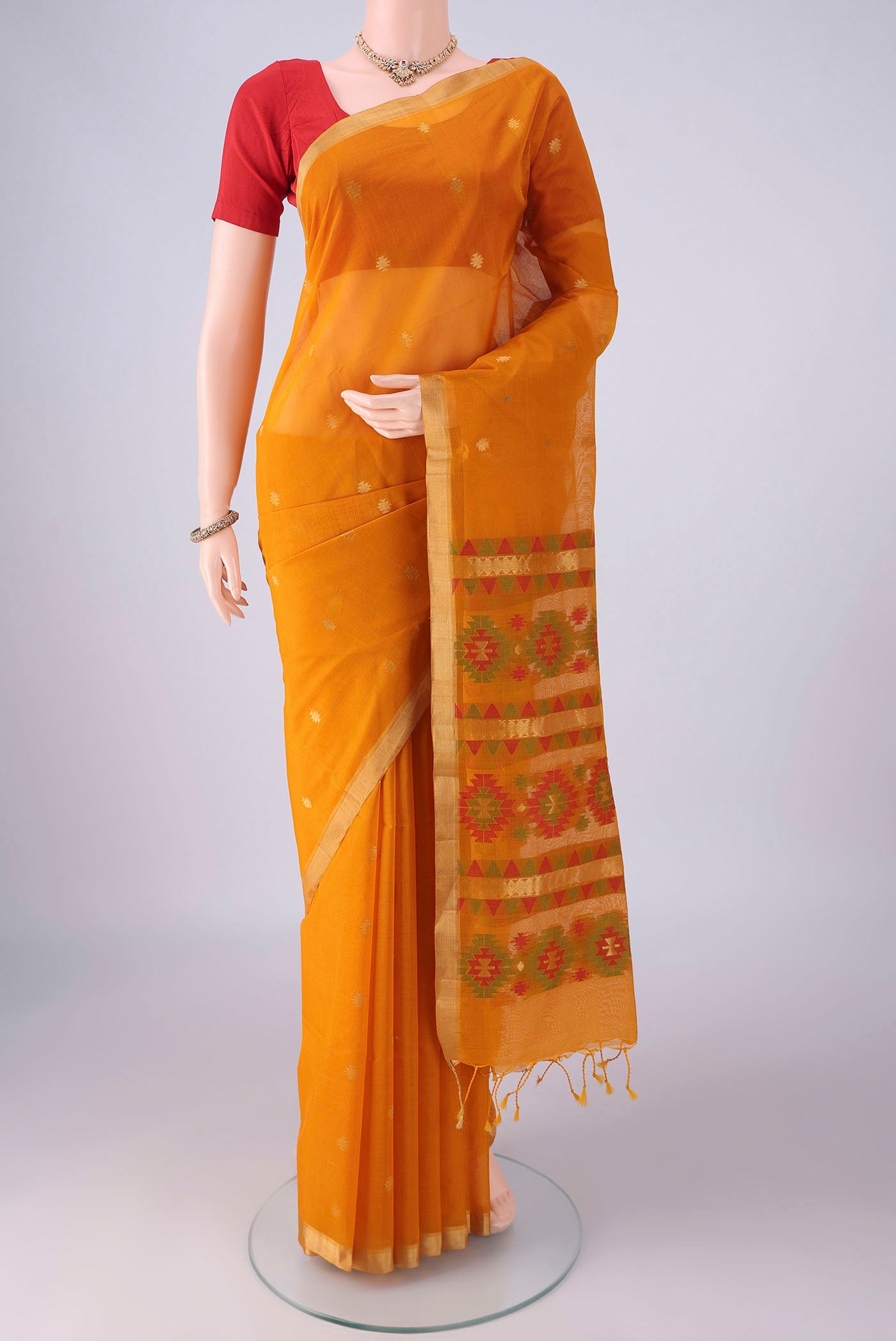 Mustard Silk Cotton Saree with Zari Butta on the body and Zari Border.  displayed on a mannequin
