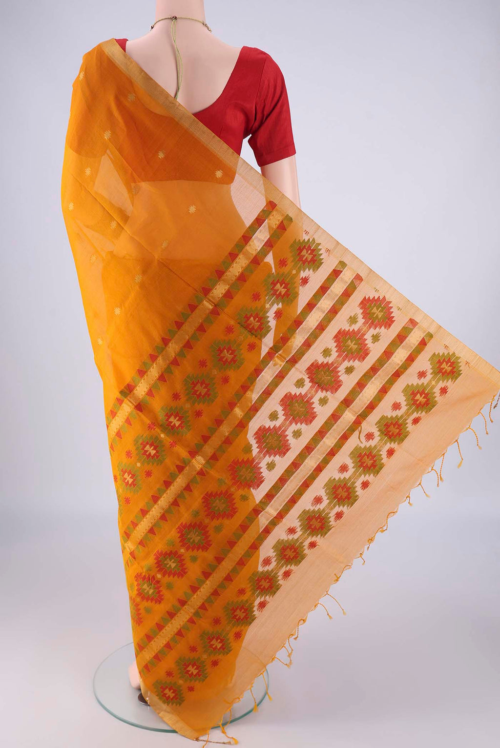 Flat view of Mustard Silk Cotton Saree with Zari Butta on the body and Zari Border. 
